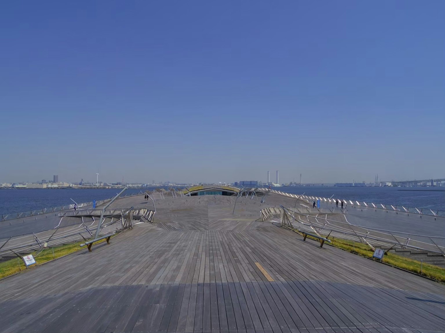 Une vue large d'une jetée s'étendant dans la mer bleue sous un ciel dégagé