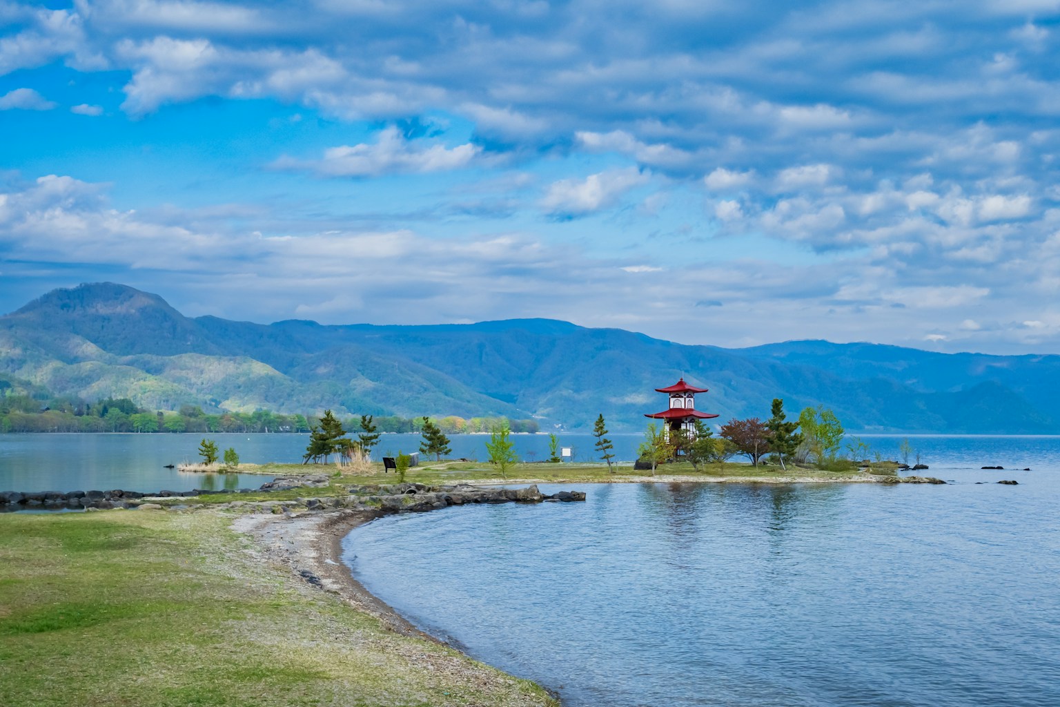 Scenic view of a blue lake with a red pavilion on an island