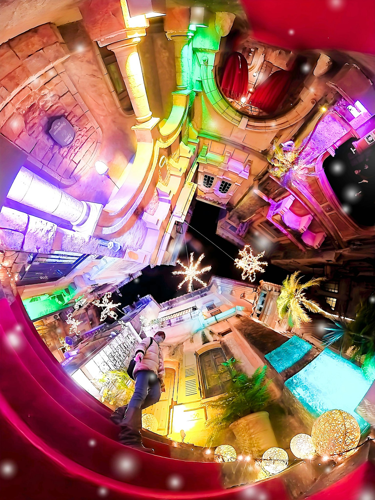 Escena callejera colorida con luces decorativas y adornos en forma de estrella