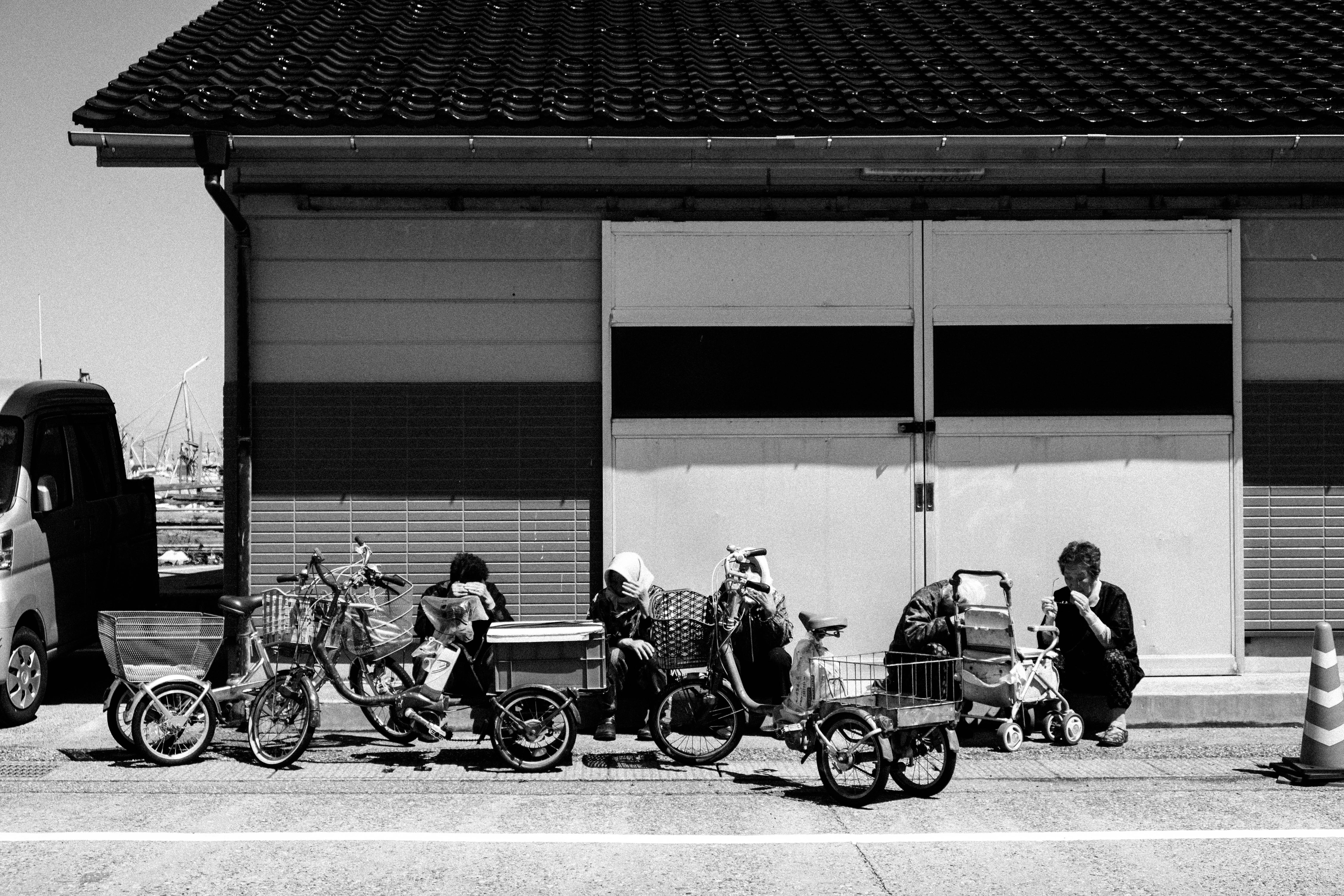 能登・輪島の路地に並ぶ自転車とバイクのある商店街の軒先
