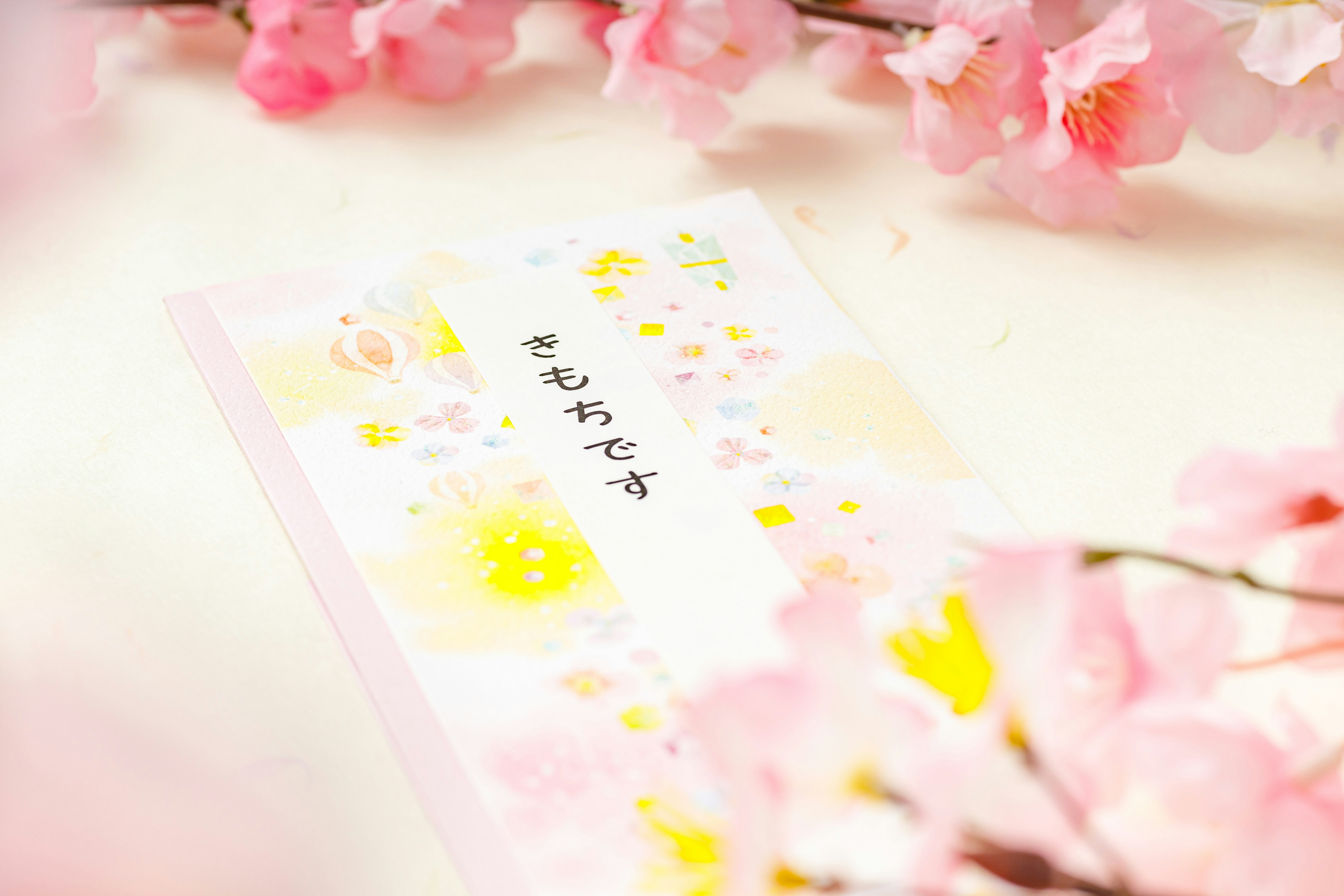 桜の花びらの上に置かれたお祝いの手紙