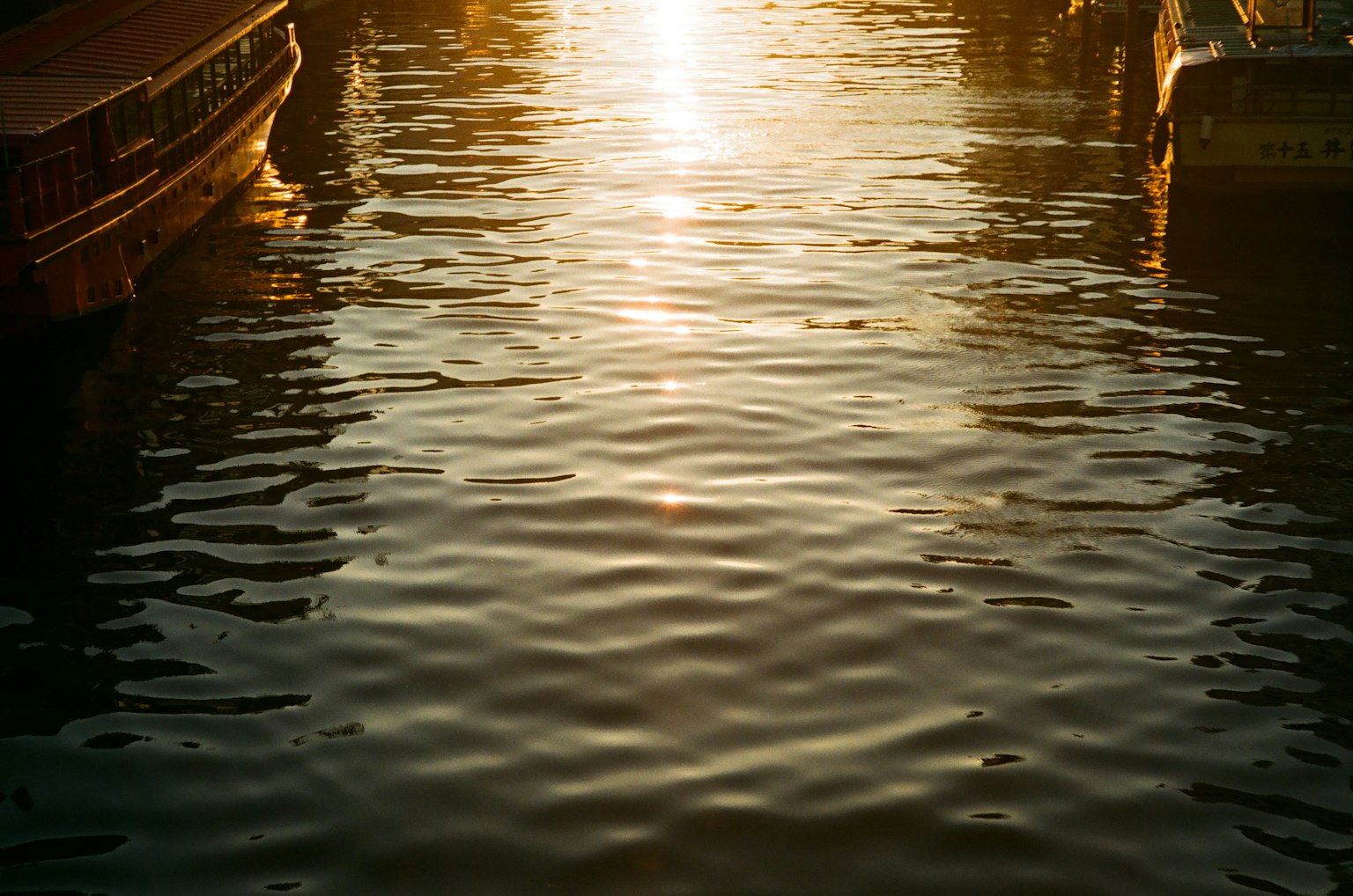 Riflesso del tramonto sull'acqua con barche tranquille
