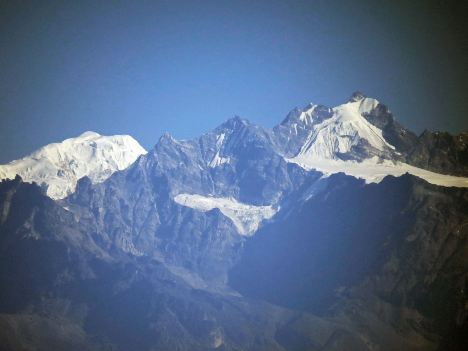 Gunung bersalju menjulang di bawah langit biru yang cerah