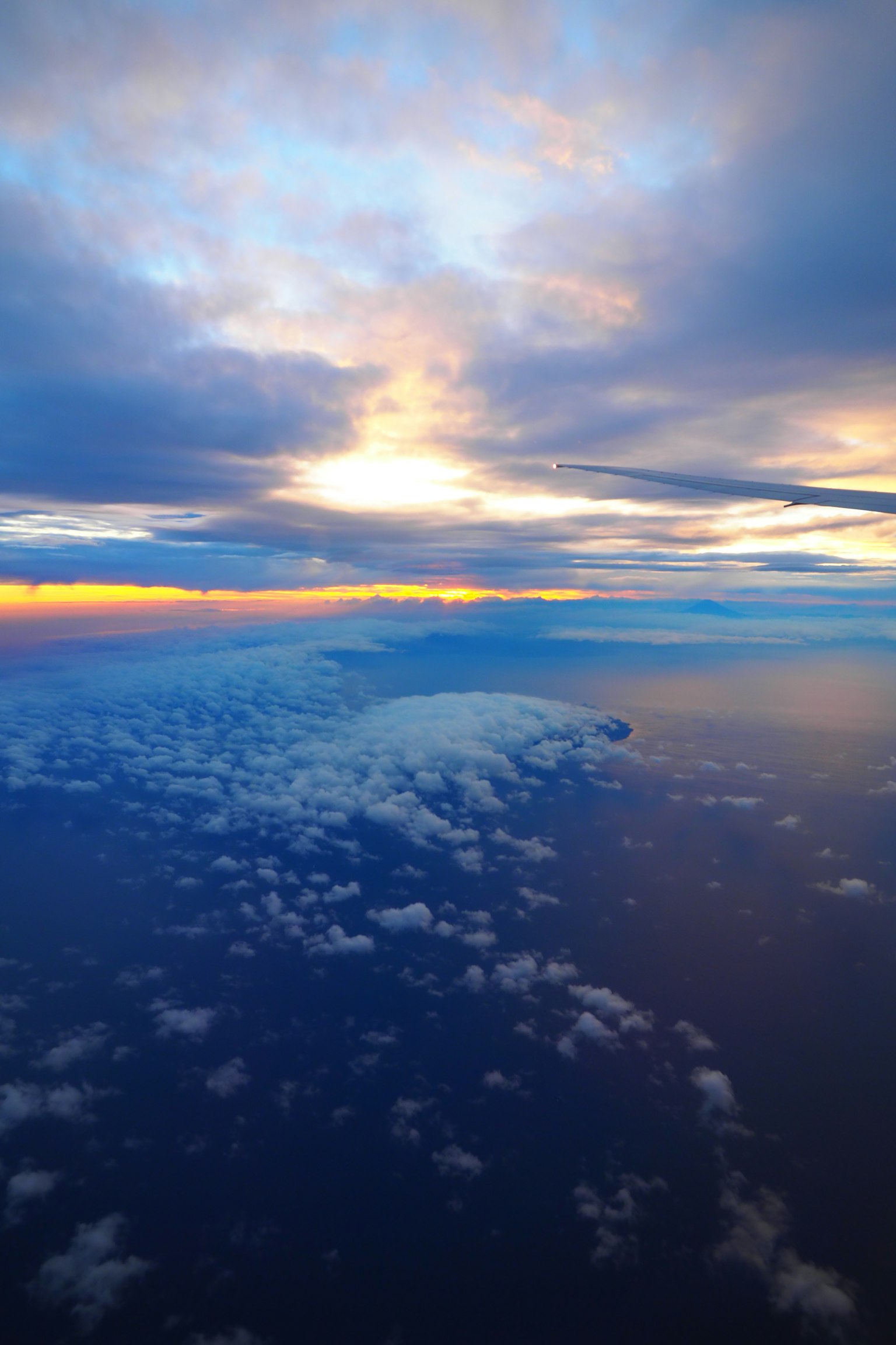 Pemandangan udara awan dengan matahari terbenam berwarna-warni di atas lautan