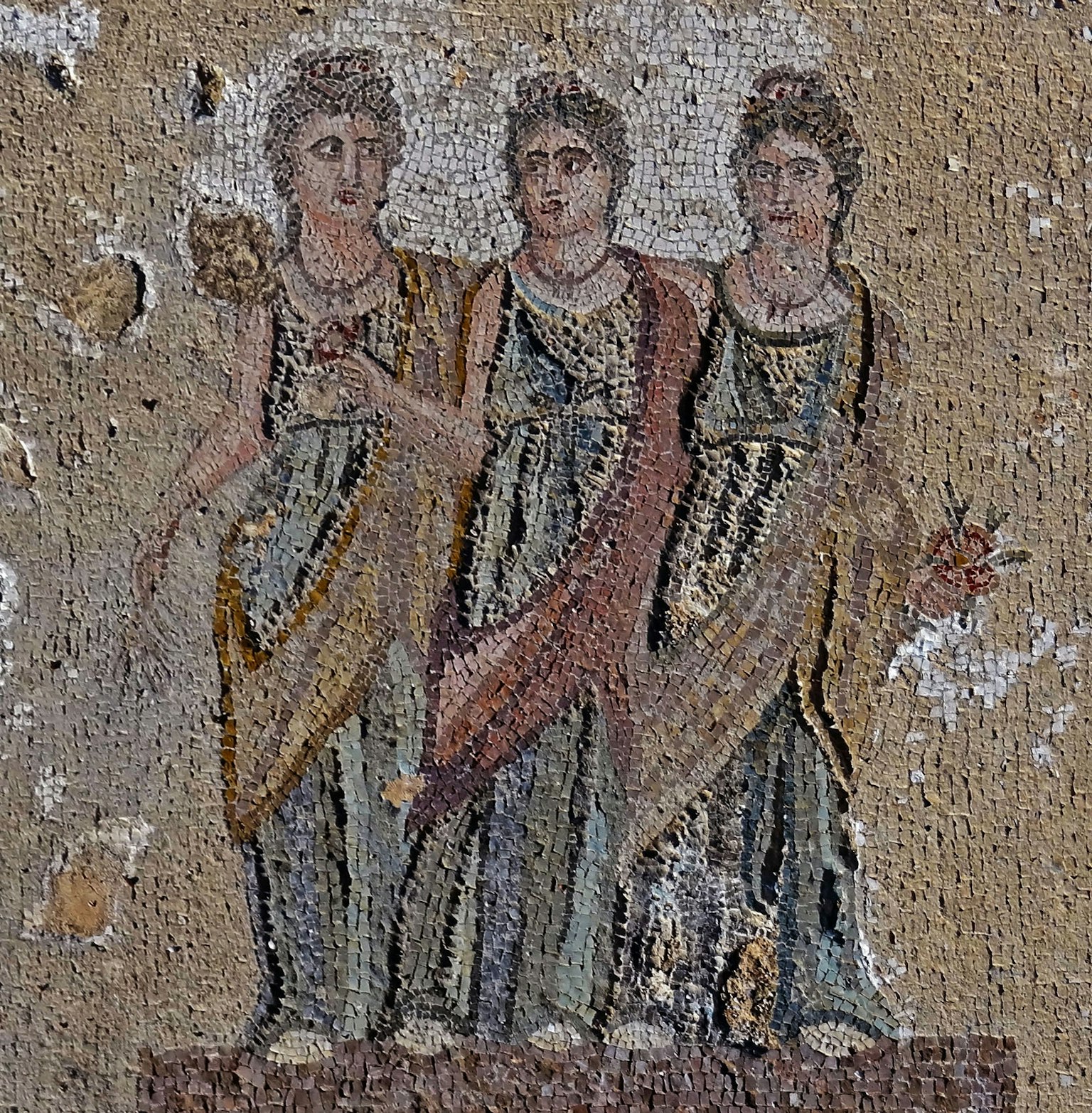 Mosaic depicting three women in ancient attire standing together
