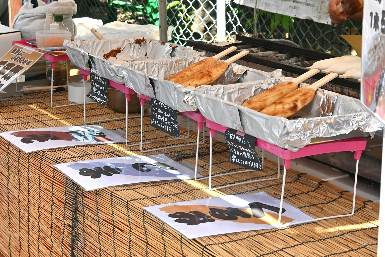 Cibo fritto esposto in vassoi argentati a uno stand di cibo