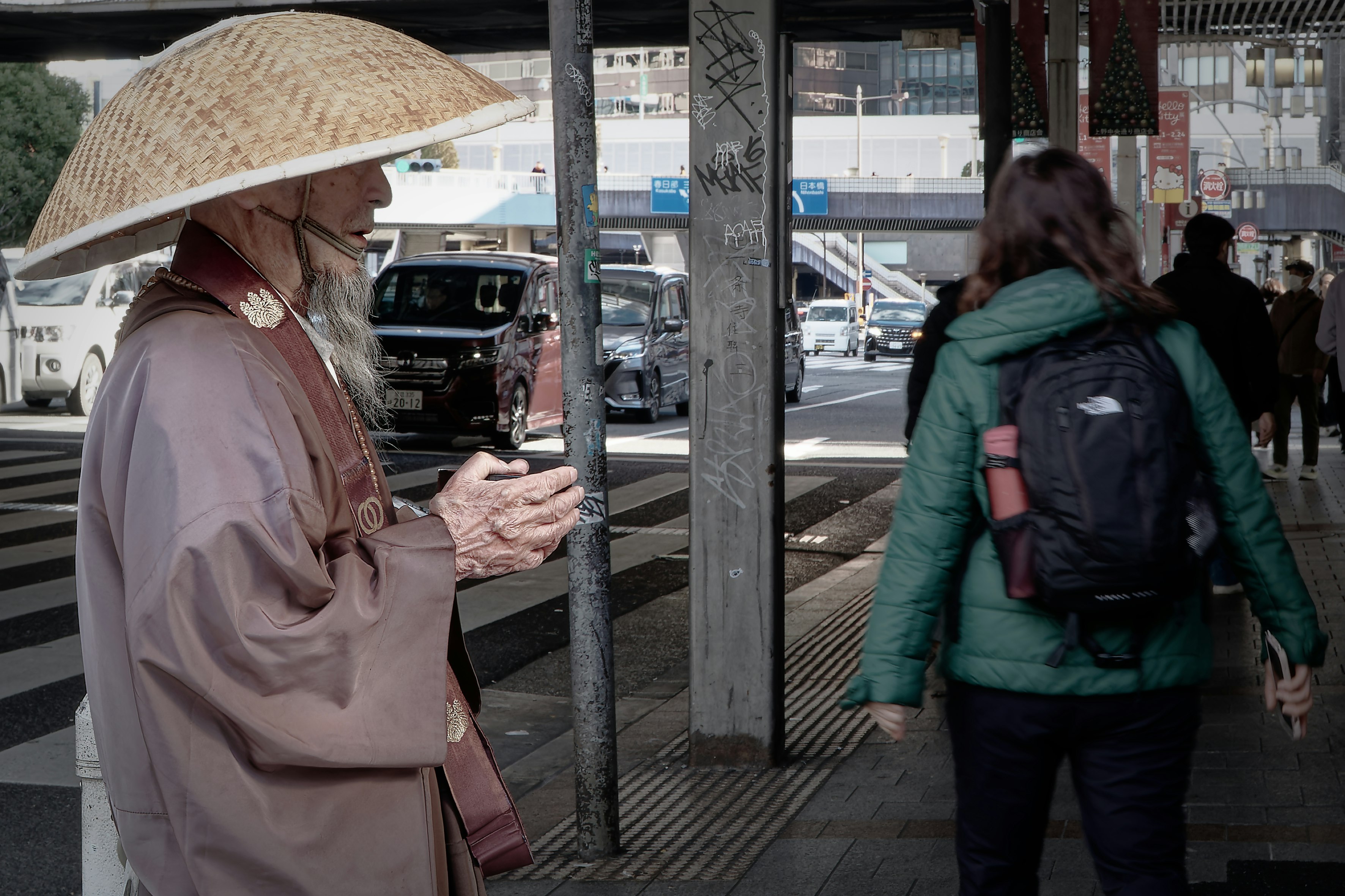 路上の托鉢をするお坊さんと通行人のスナップ