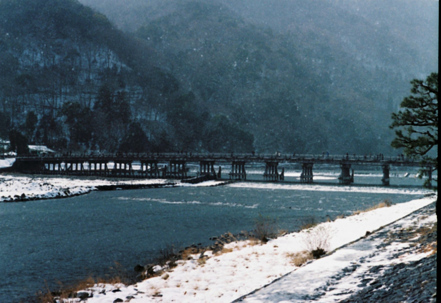 雪覆蓋的河流和山脈風景，橋橫跨河流