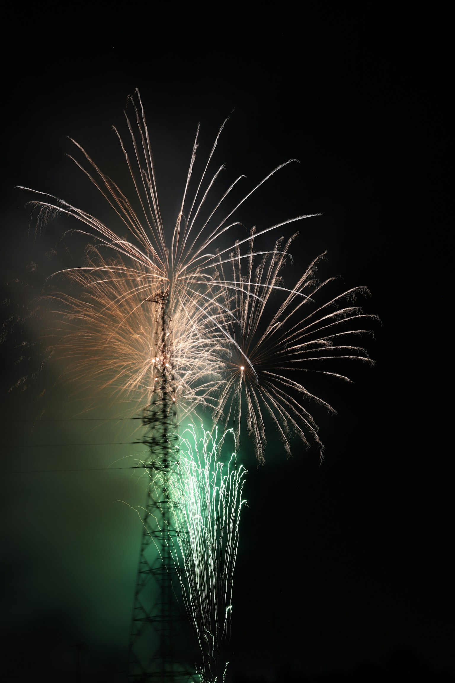 Feux d'artifice illuminant le ciel nocturne avec la silhouette d'une tour