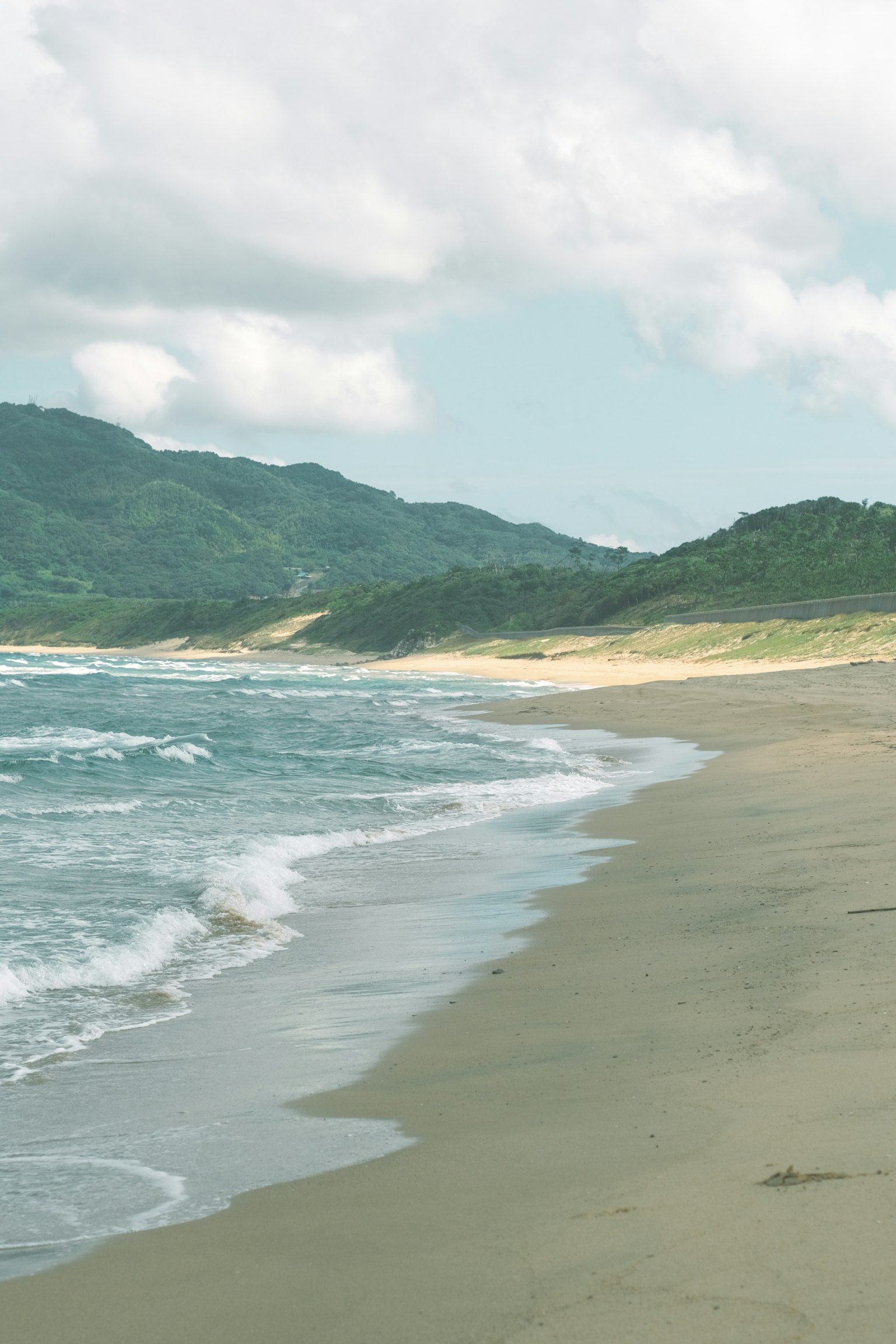 Ruhige Strandlandschaft mit sanften Wellen und Küste