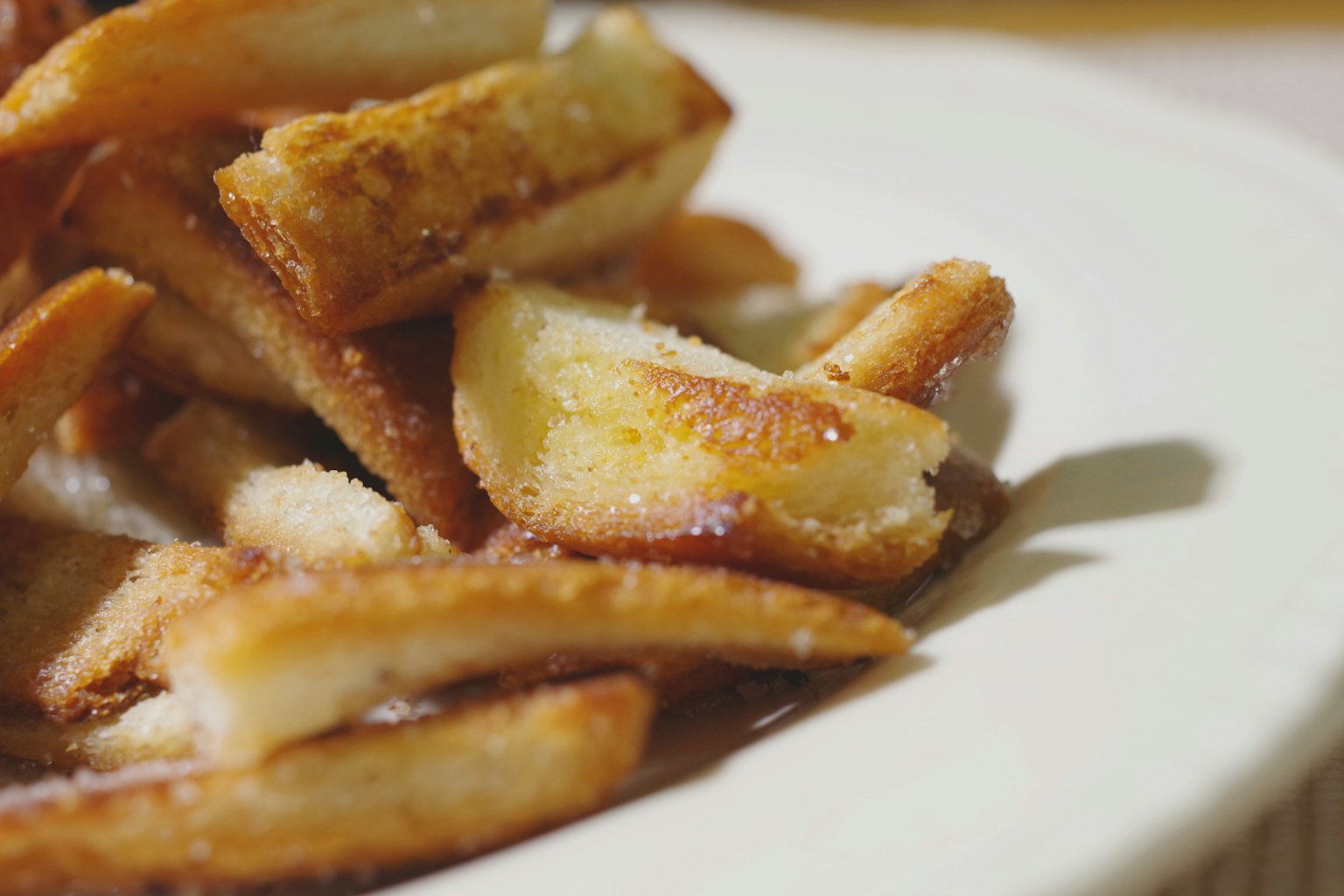 Close-up kentang goreng renyah di piring putih