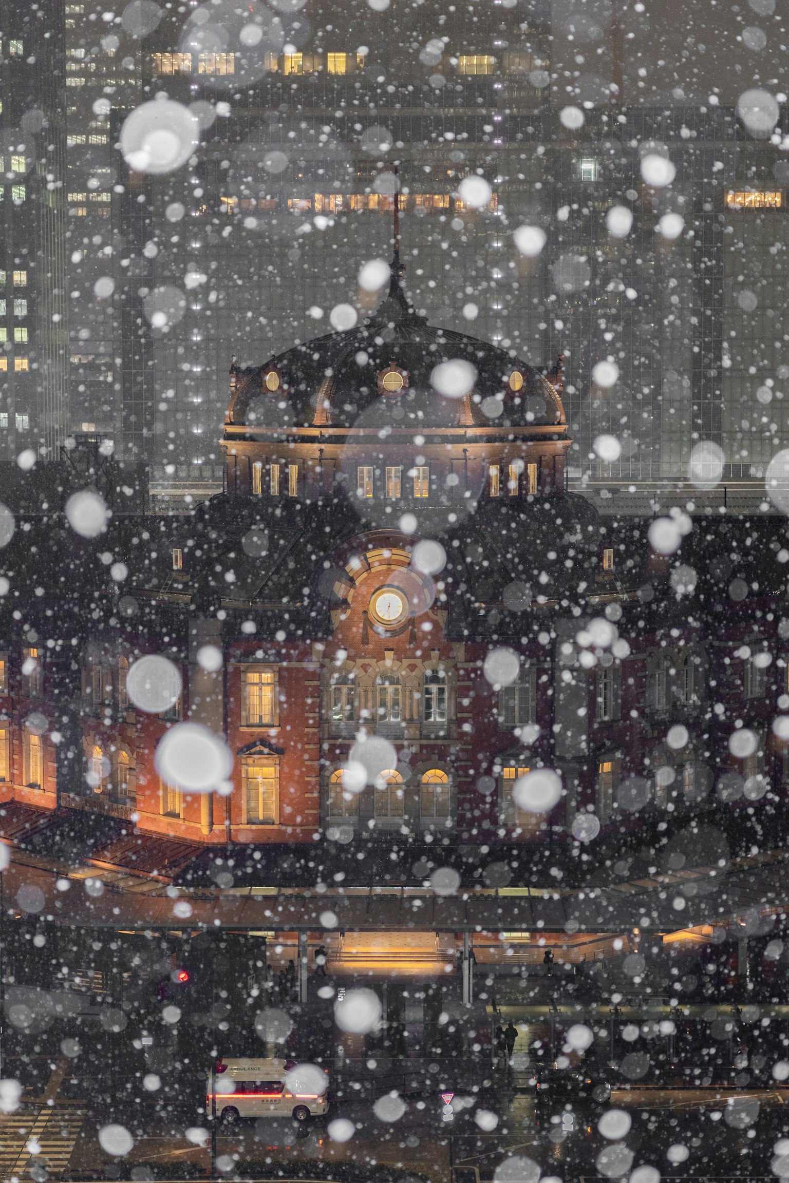 雪夜城市風景，大雪紛飛，背景中燈光閃爍的建築物