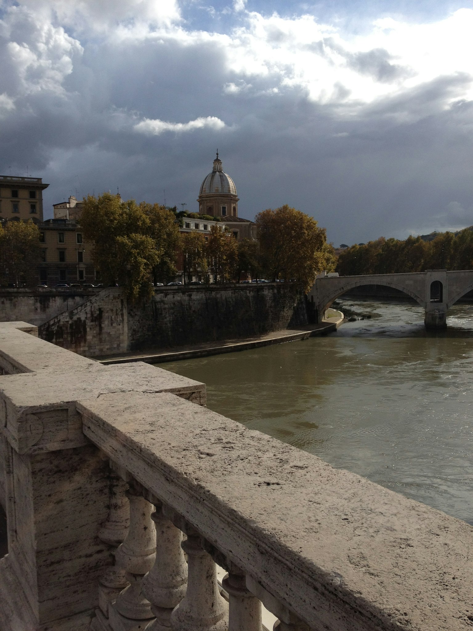 Vista di Roma dal fiume Tevere con ponte e cielo nuvoloso