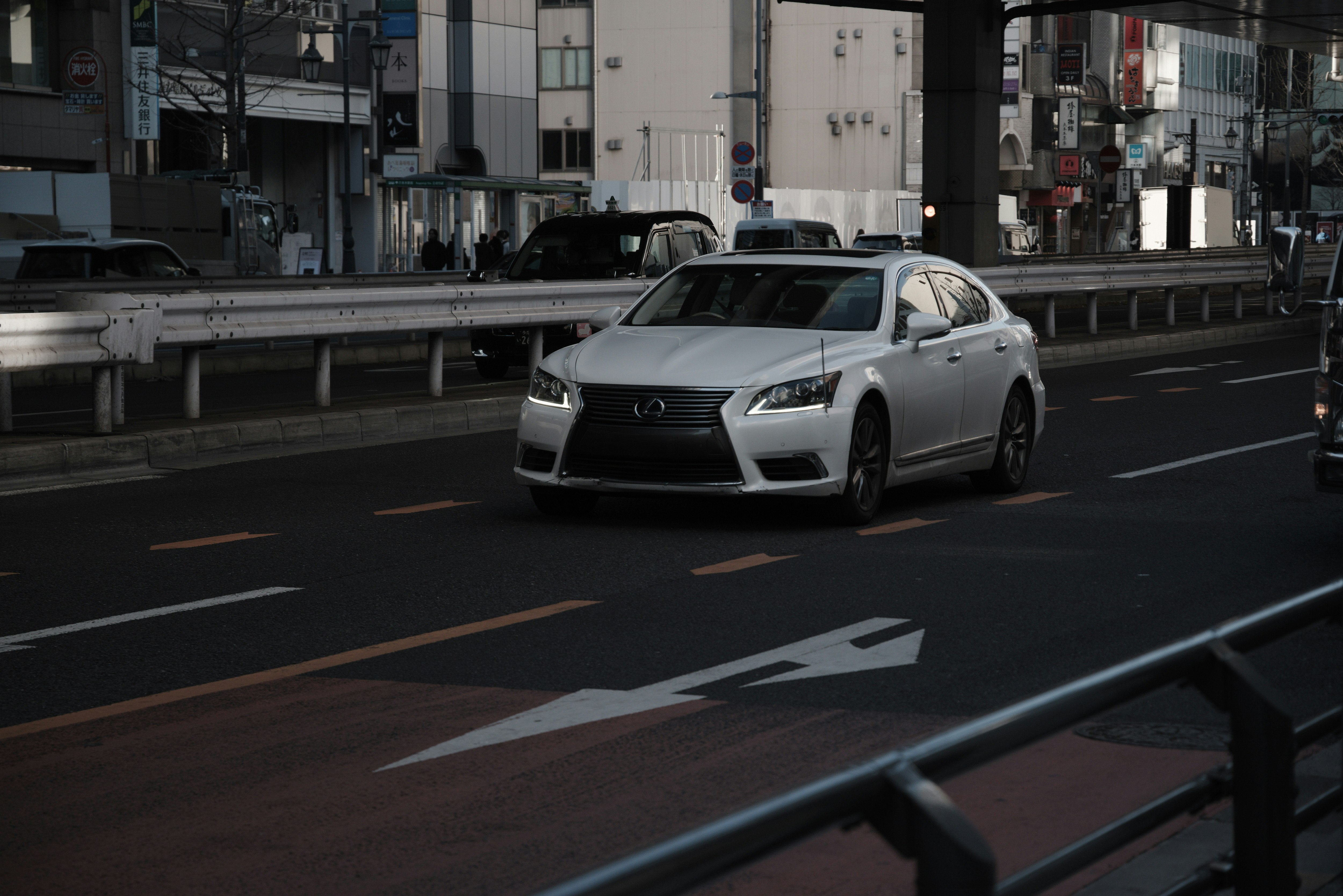 Lexus sedan driving on a city road