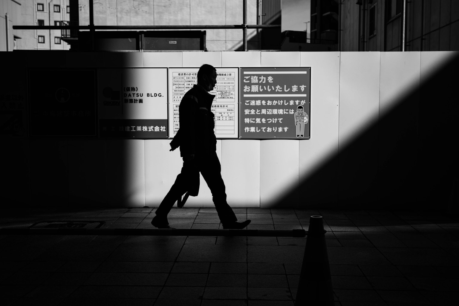 高对比度的黑白图像，剪影走过标志