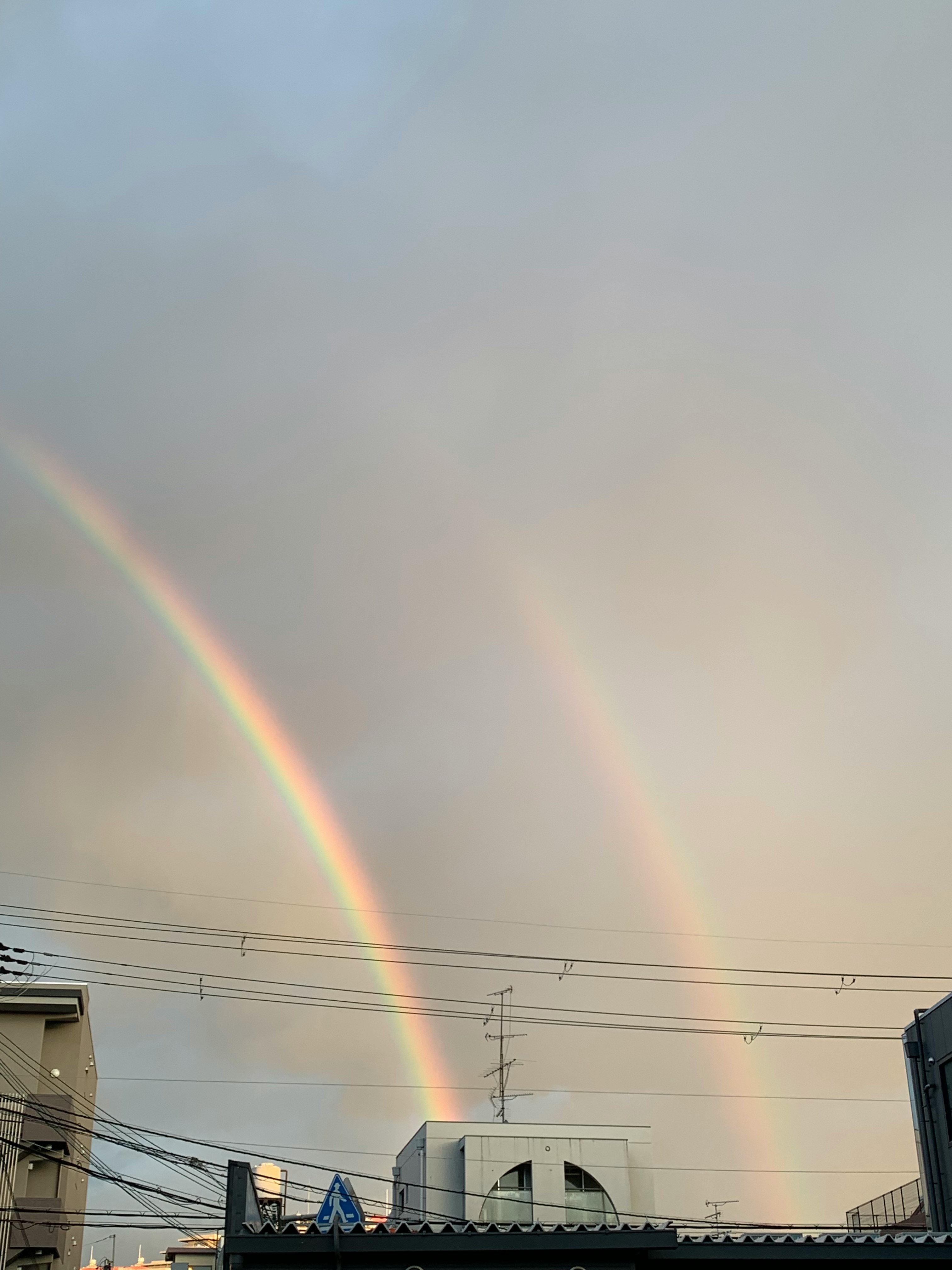 doppio arcobaleno sopra il profilo urbano al crepuscolo