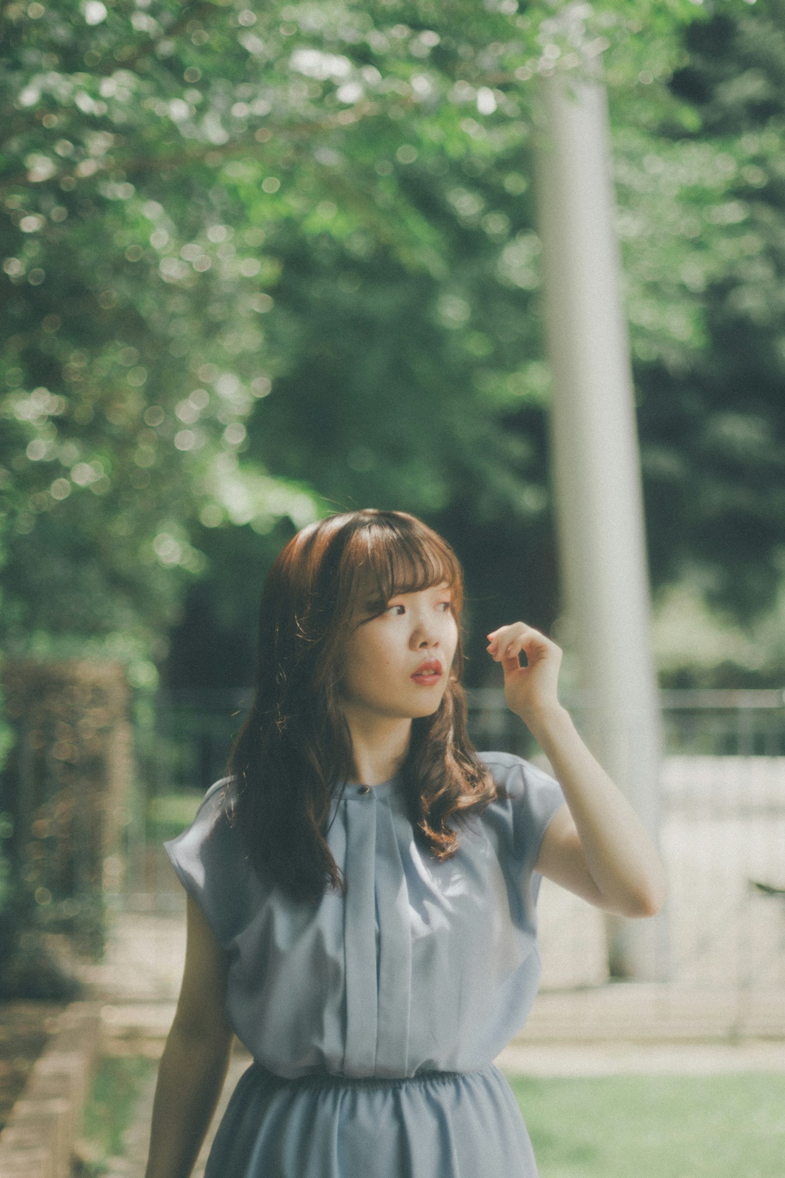 Woman in blue dress walking in a green background
