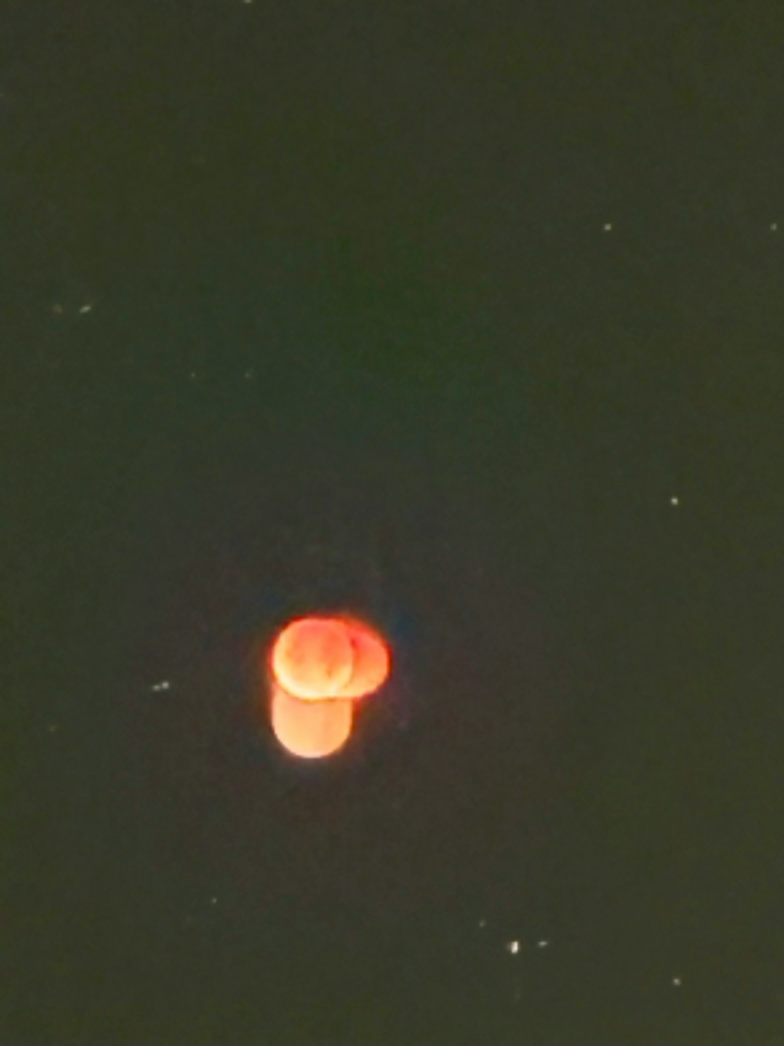 Two red circular shapes floating against a dark background