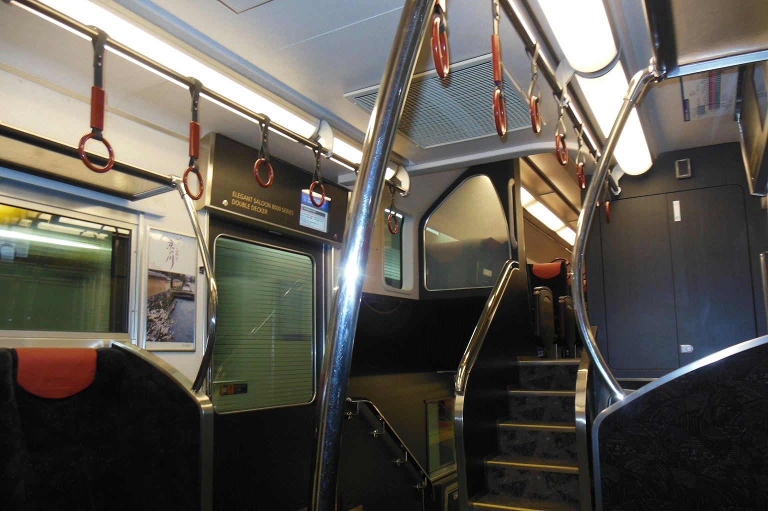 Interior de un tren con una escalera y pasamanos