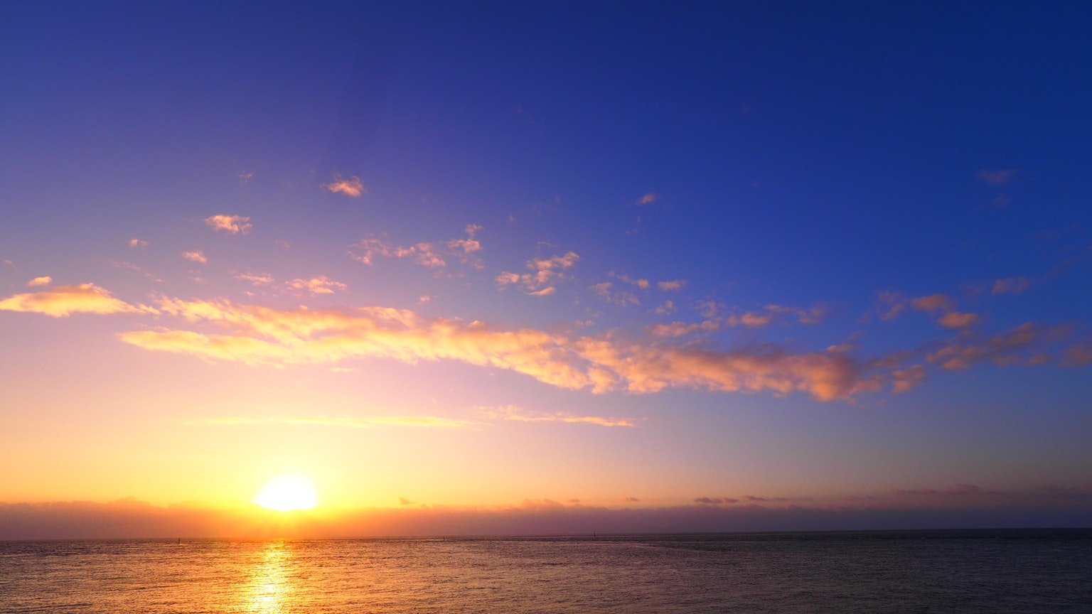 Sunset indah di atas laut dengan langit biru gradasi