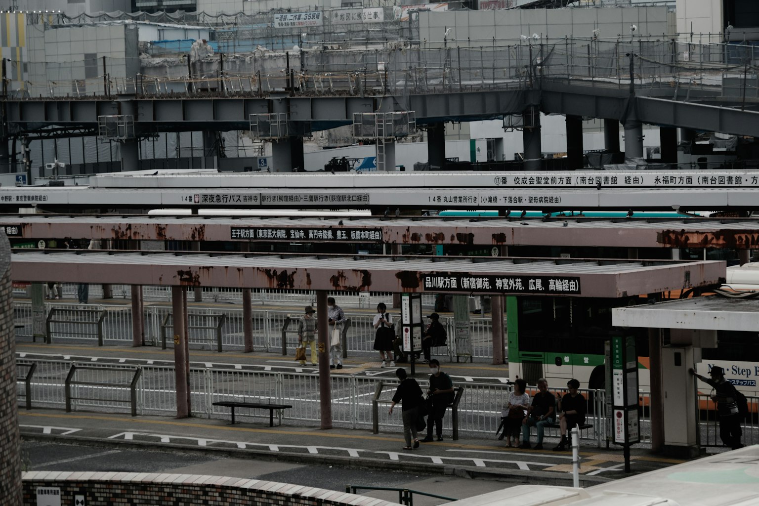 Pemandangan stasiun kereta perkotaan dengan orang-orang menunggu di platform dan beberapa kereta