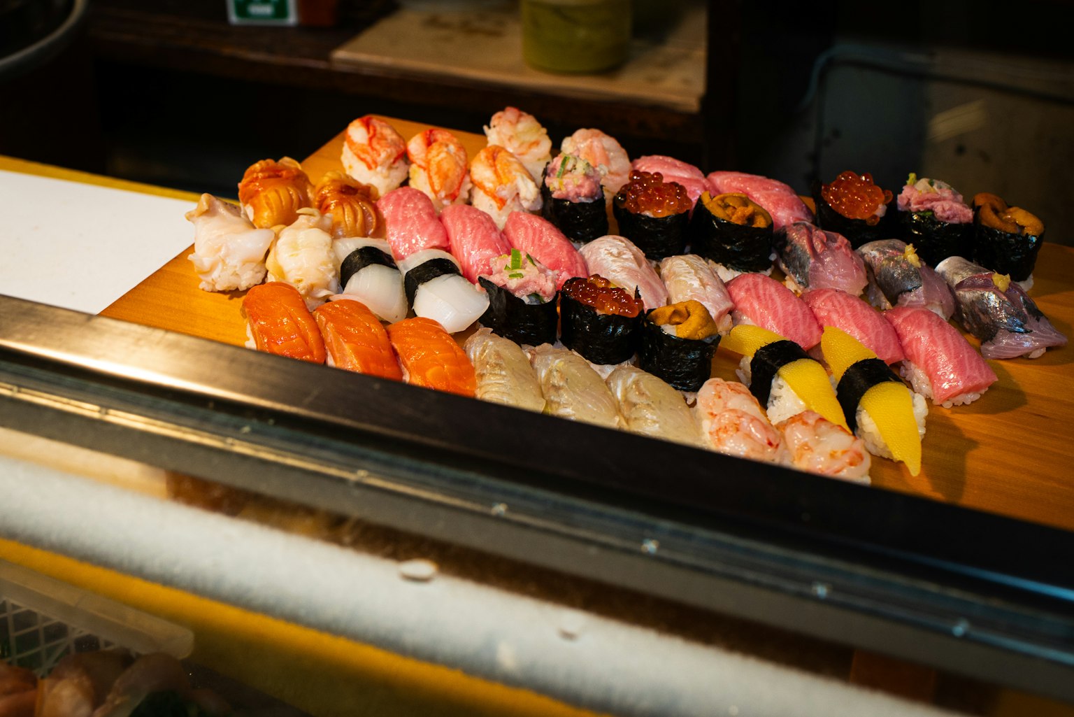 Una colorida variedad de sushi exhibida en una tabla de madera