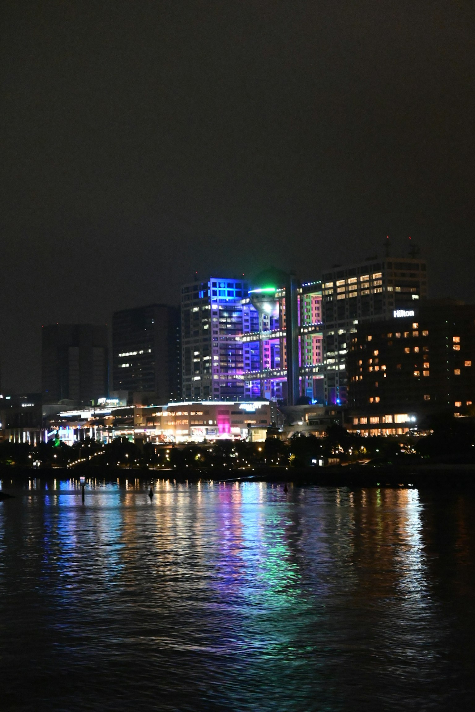 夜晚城市天際線的彩色燈光映在水面上