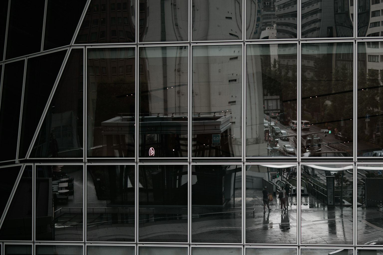 Reflets d'un paysage urbain et silhouettes de personnes sur un mur en verre