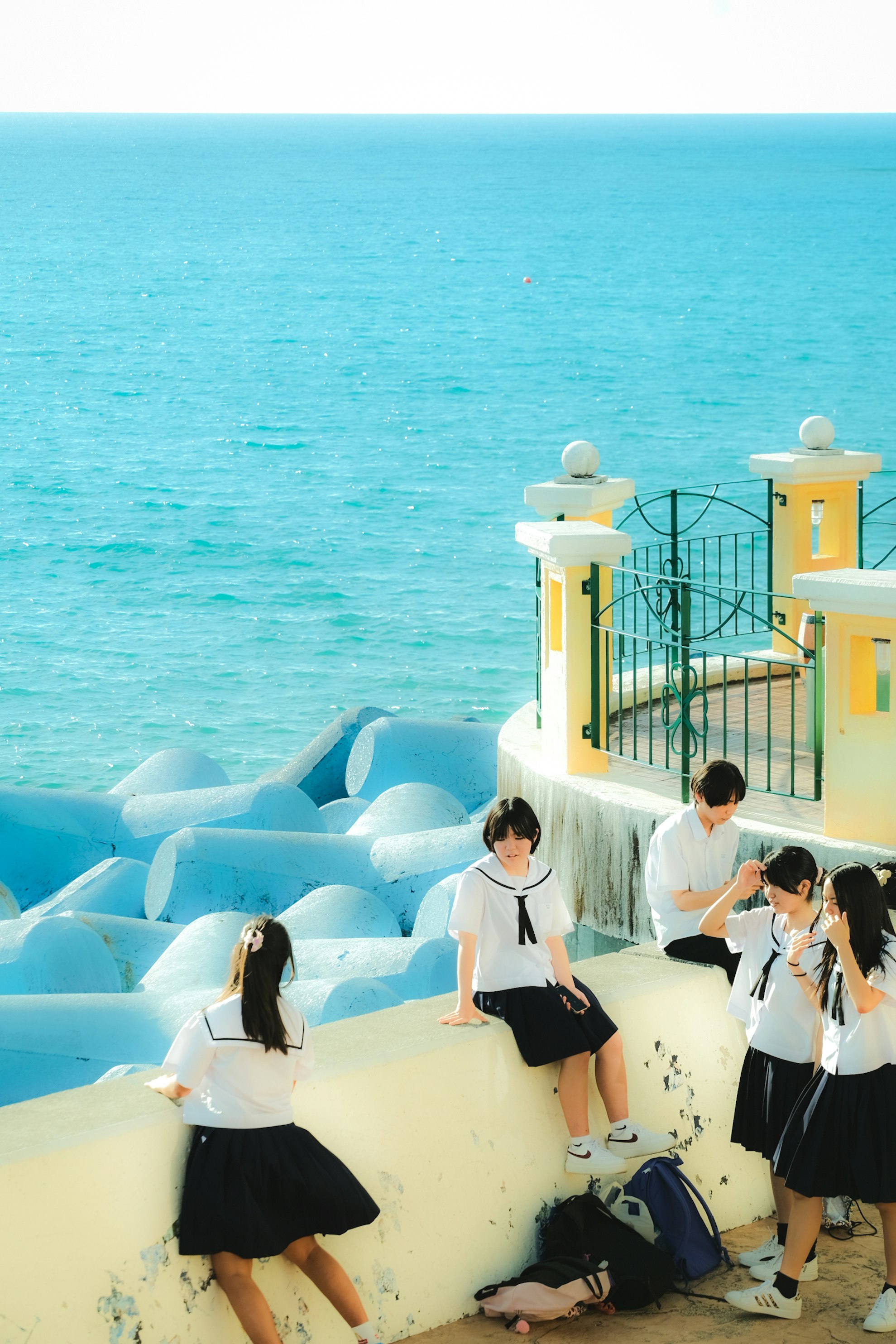 Des étudiants rassemblés sur des marches blanches au bord de la mer