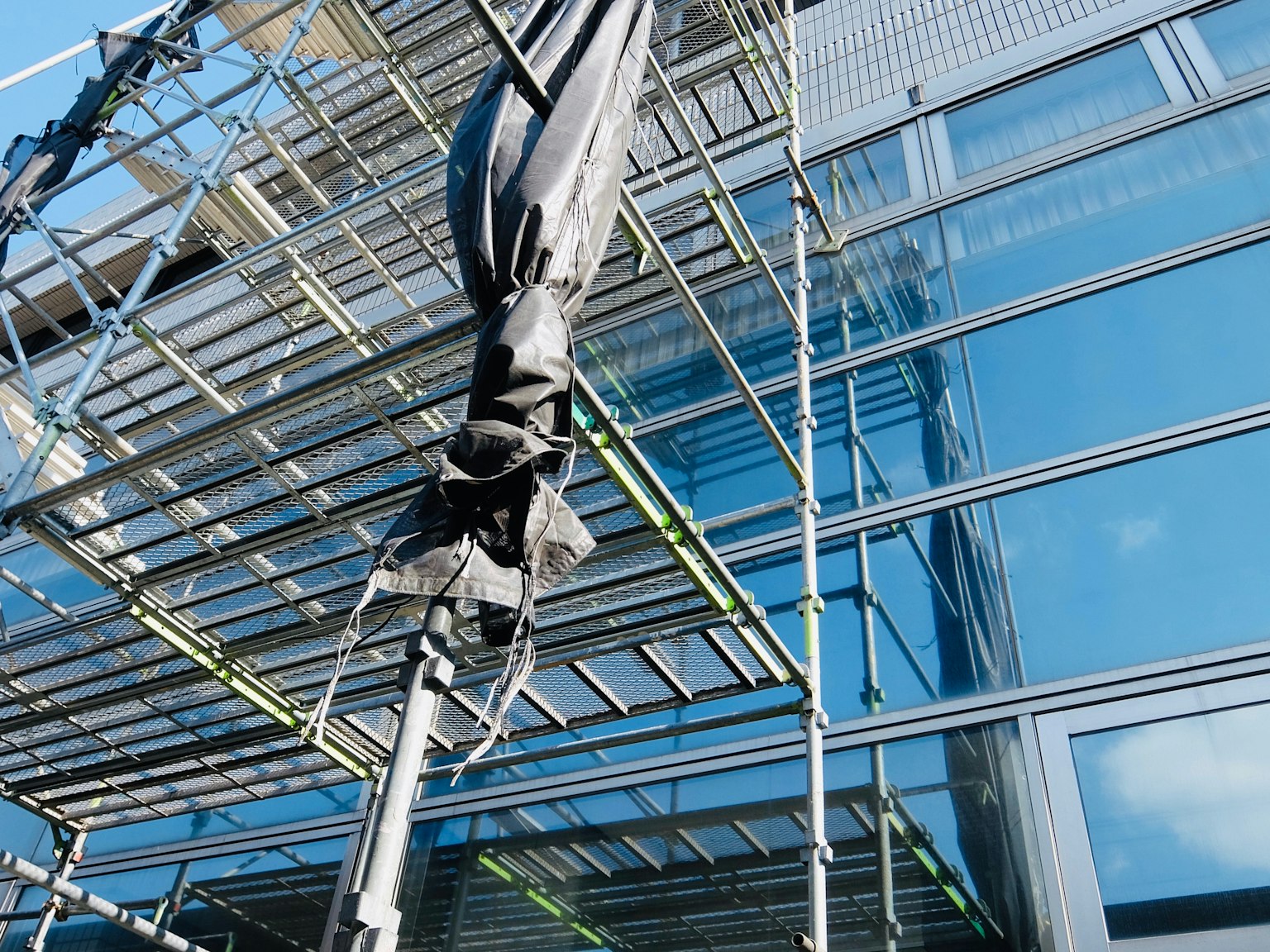 Part of a building with glass facade and scaffolding
