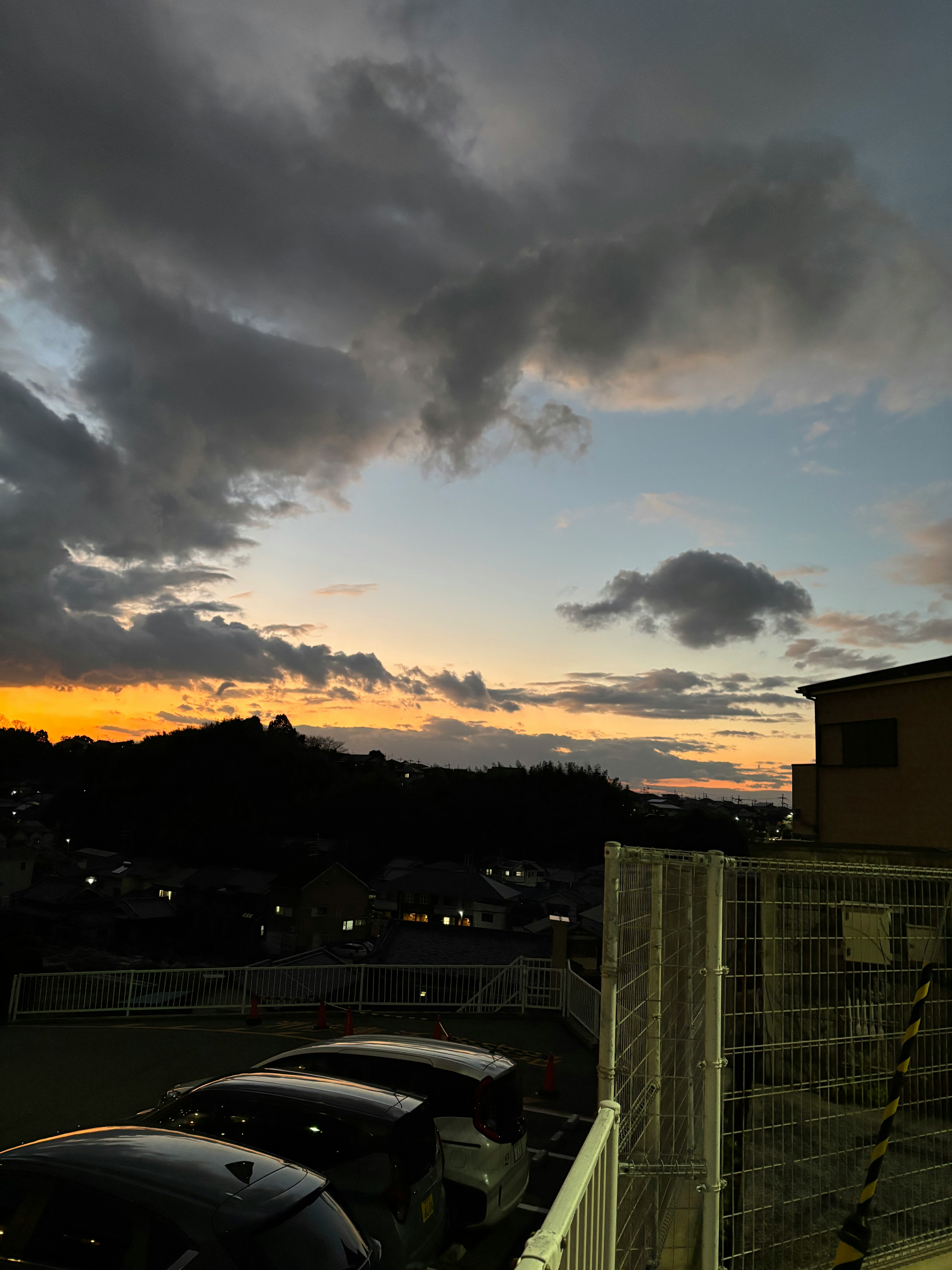 parcheggio con auto e cielo al tramonto sopra un quartiere residenziale