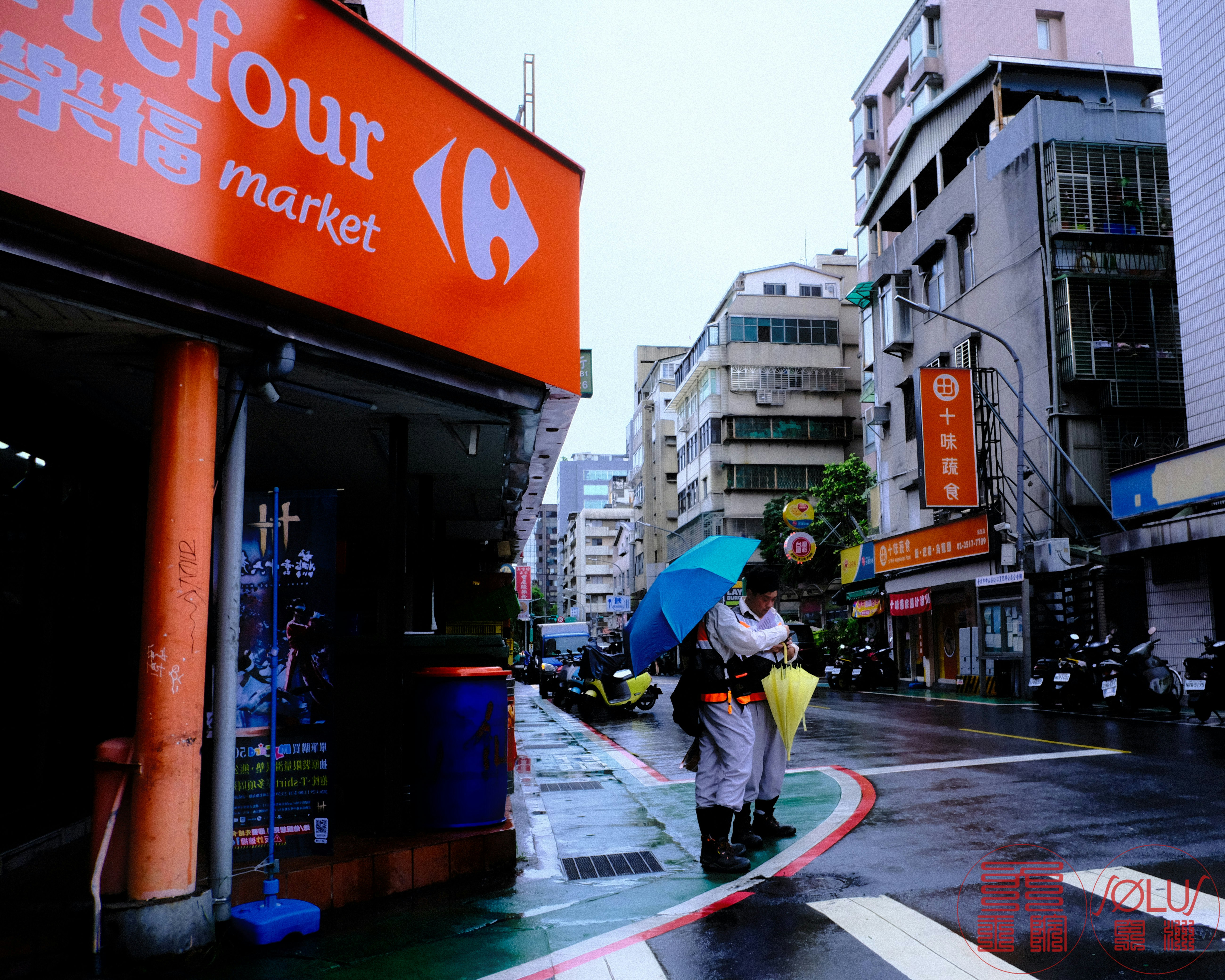 台北の路地にある市場の軒先と雨の傘のスナップ