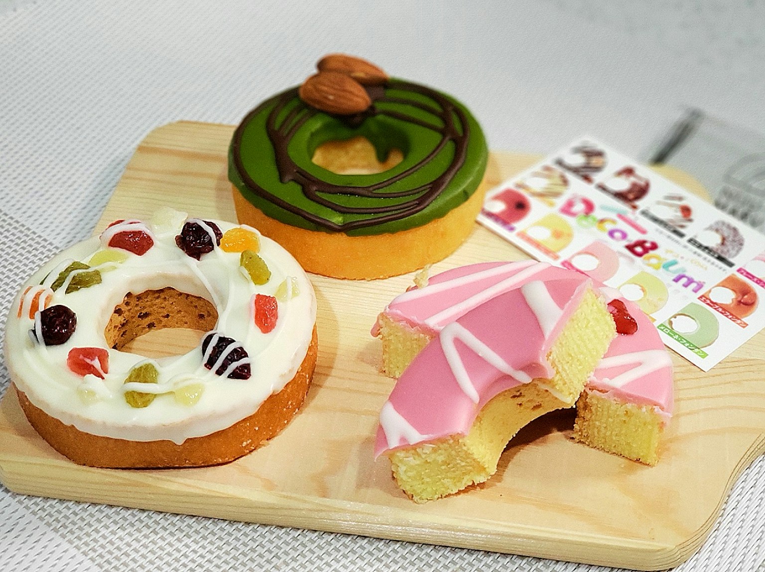 Donuts e torta decorati colorati disposti su un piatto di legno