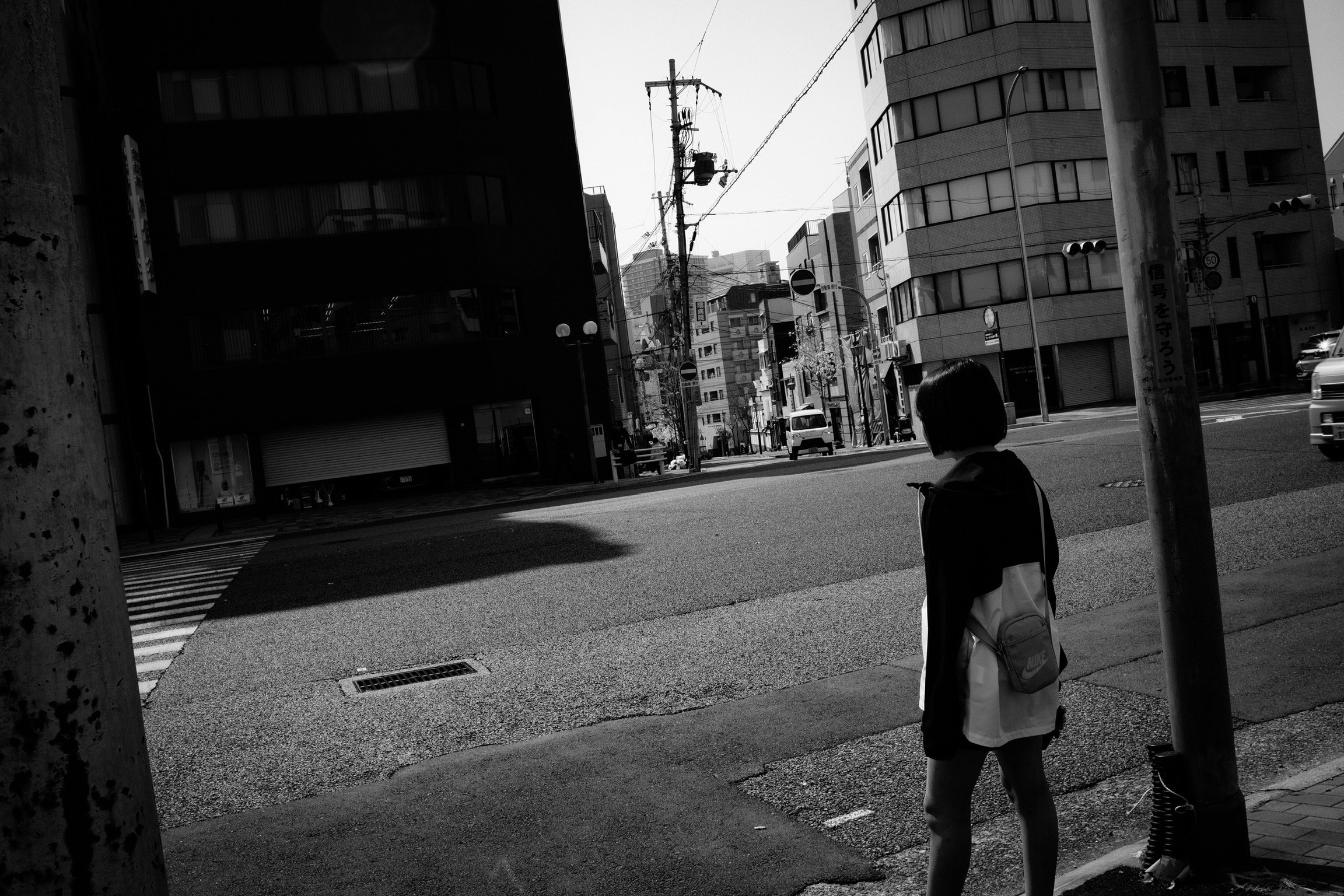 モノクロの路地で歩く人物と街並み