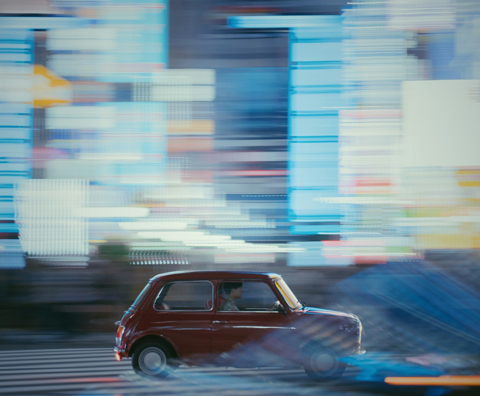 一輛紅色汽車在充滿活力的城市背景中飛馳