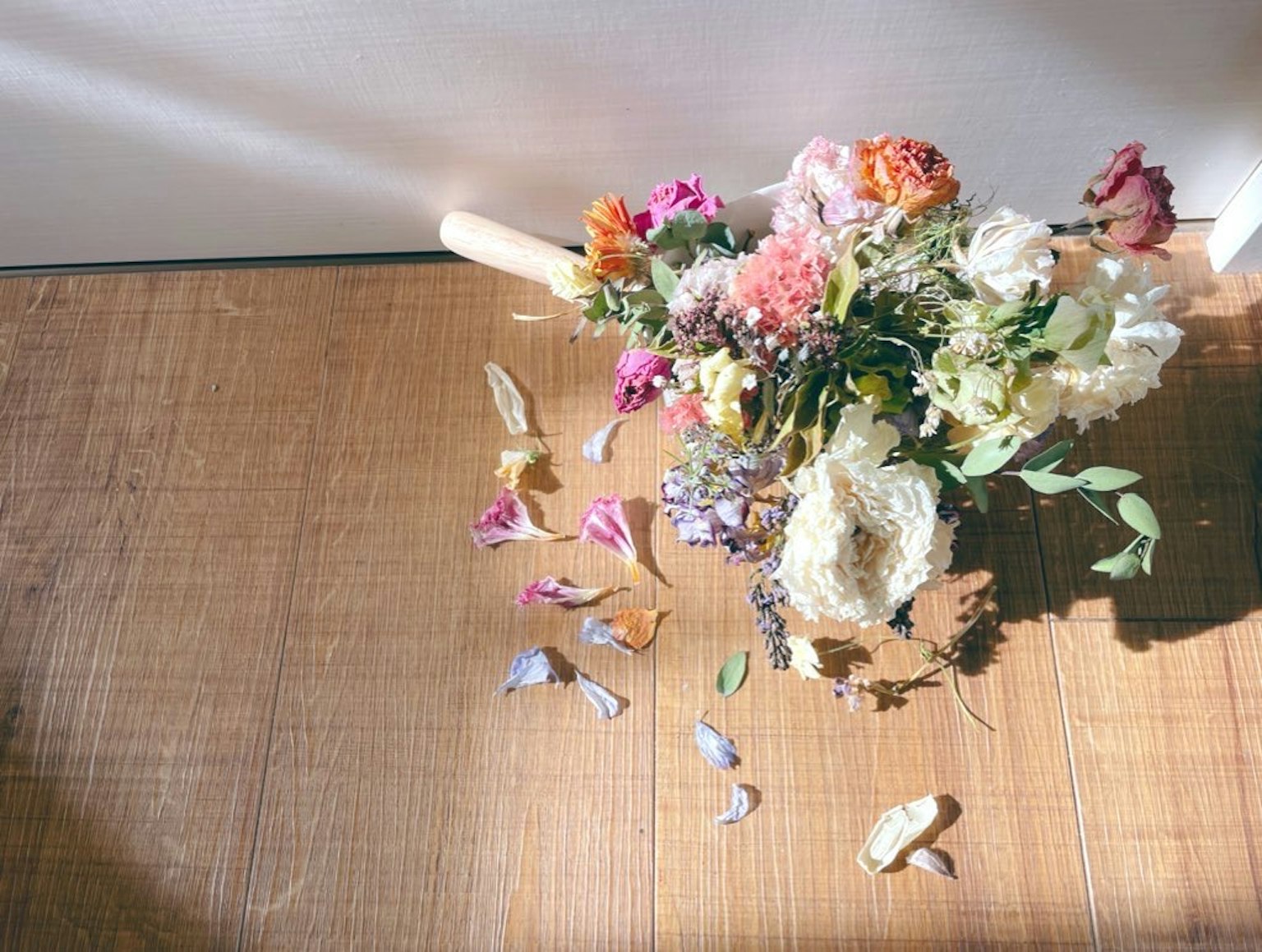 Ein bunter Strauß aus getrockneten Blumen auf einem Holztisch