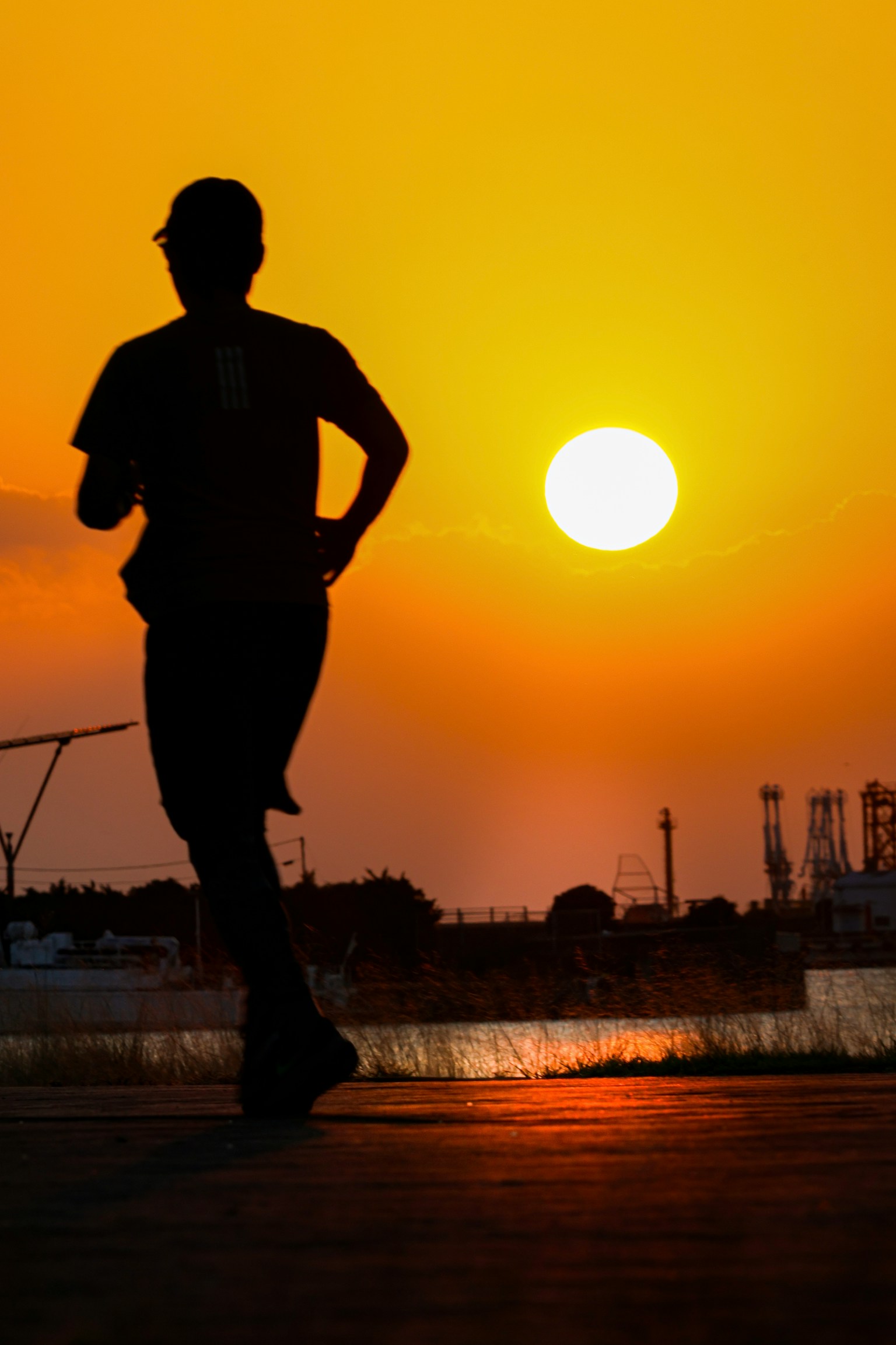 Silhouette einer Person, die gegen einen Sonnenuntergang läuft