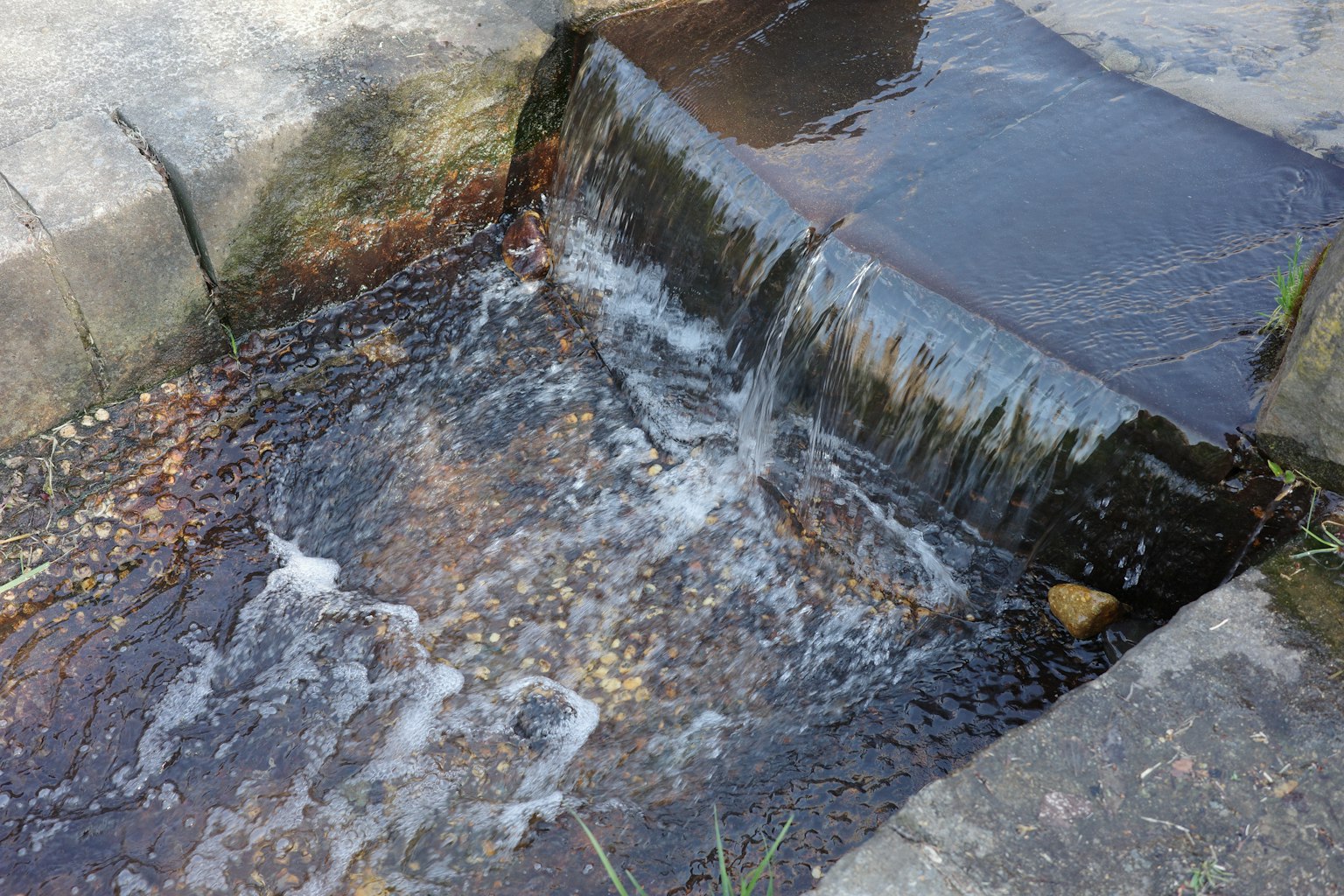 Eau s'écoulant sur des marches en pierre dans un petit ruisseau