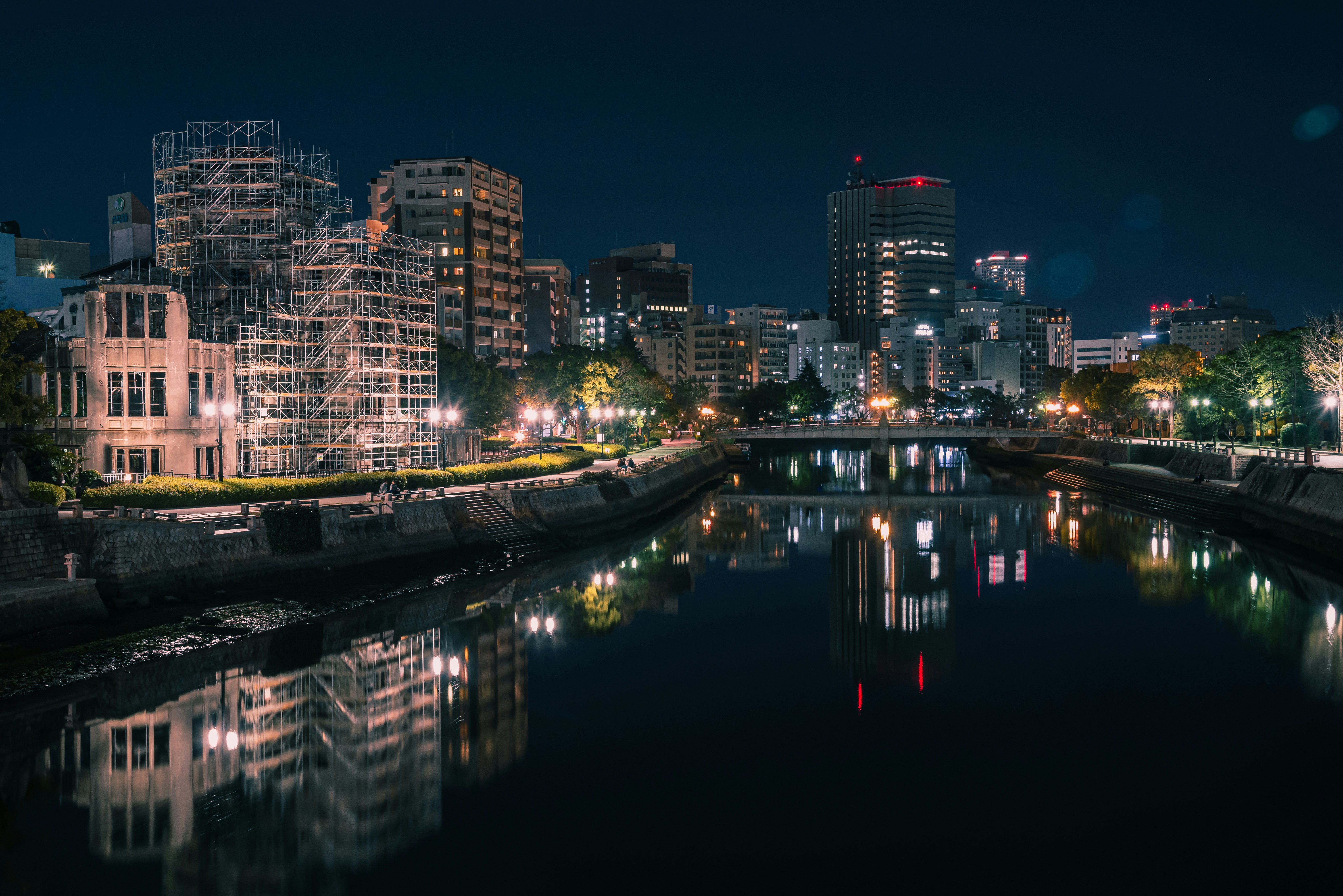 reflejos de rascacielos en un río de noche con luces de la ciudad