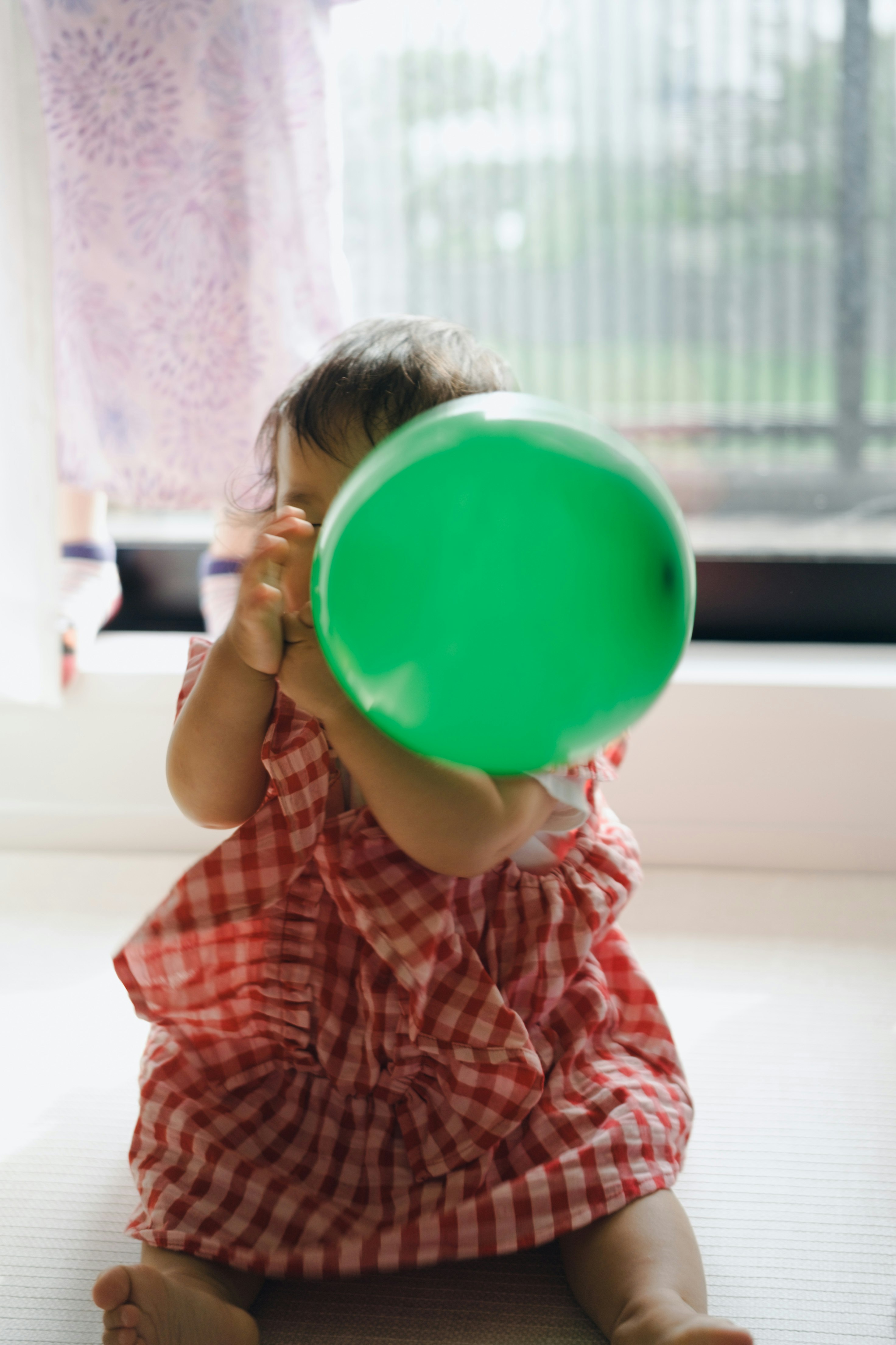child holding a green balloon