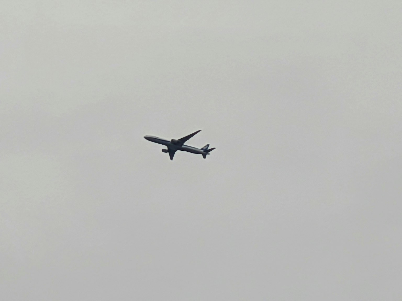 Un avion volant dans un ciel gris