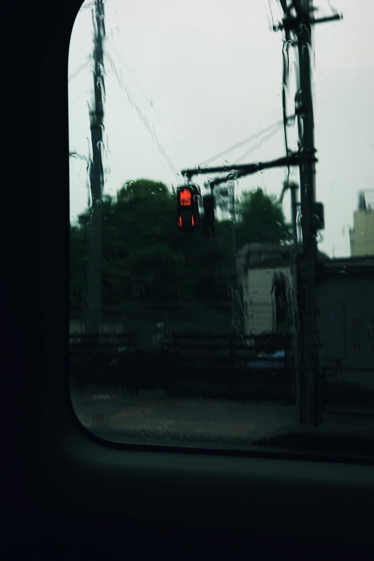 窓越しに見える雨の街並みと信号