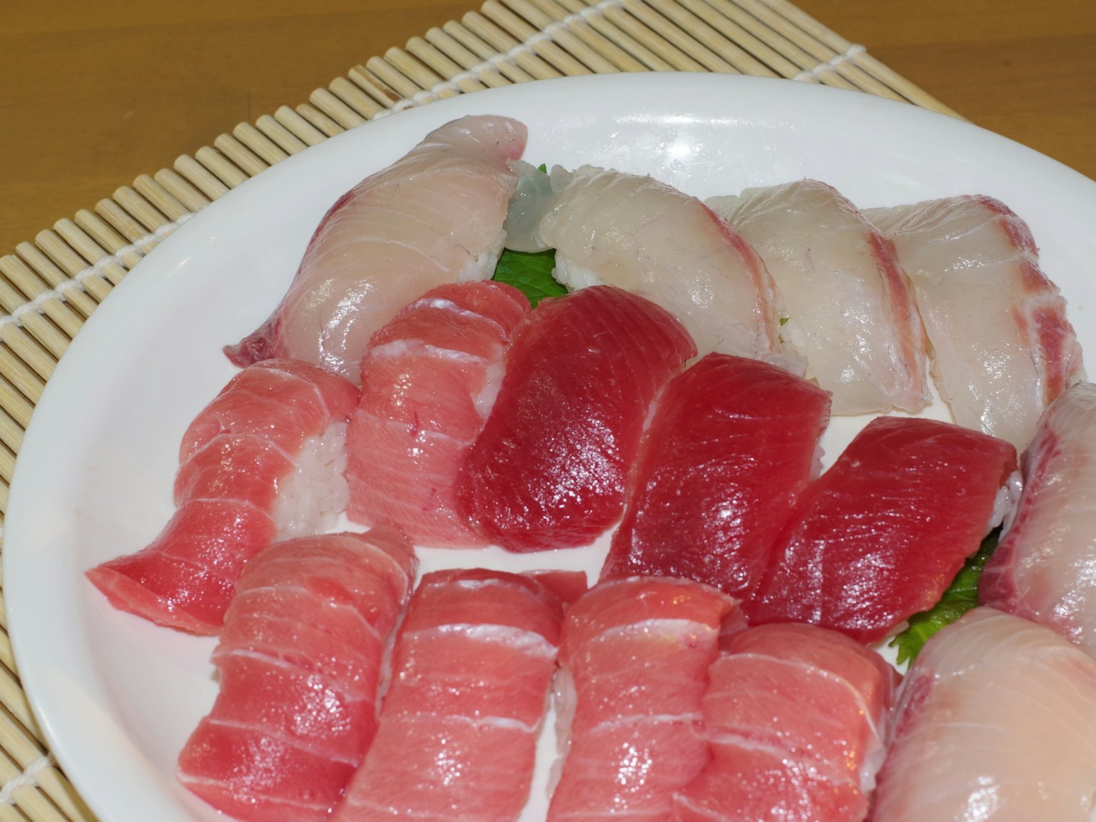 Piring sushi segar dengan irisan tuna dan ikan putih yang berwarna-warni