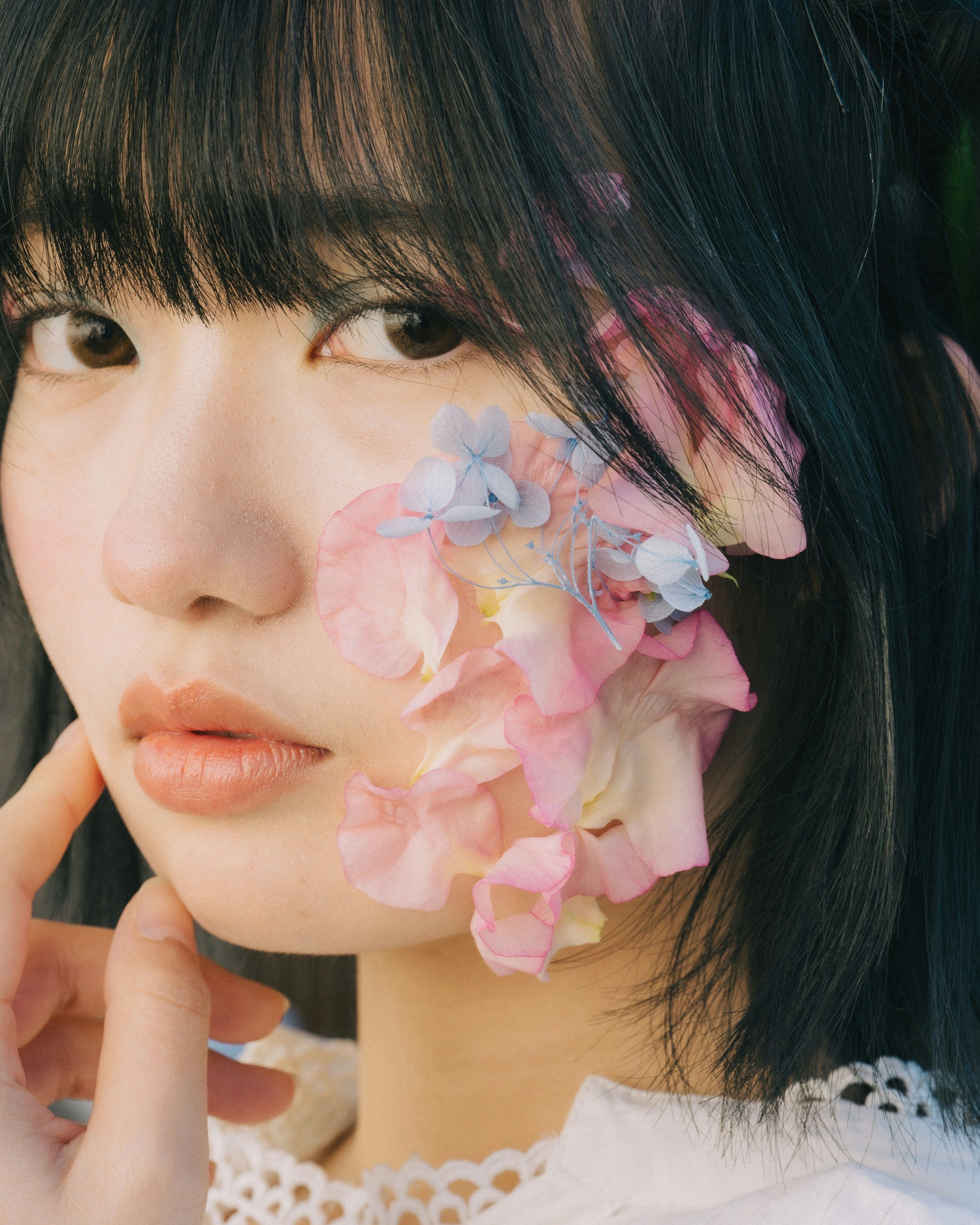 花びらのエフェクトが重なる横顔の女性