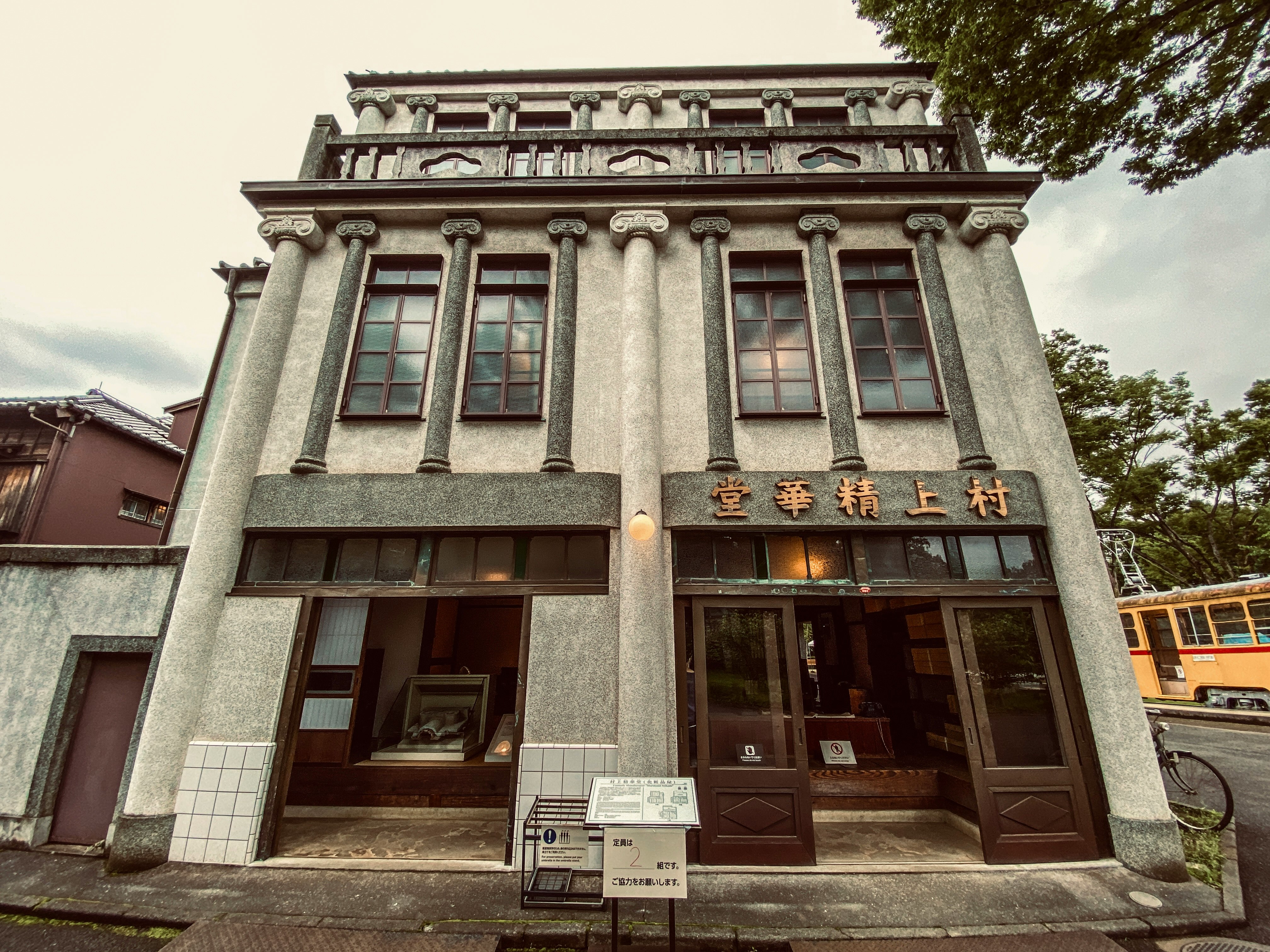 石造りの建物の正面と看板のある商店街の通り