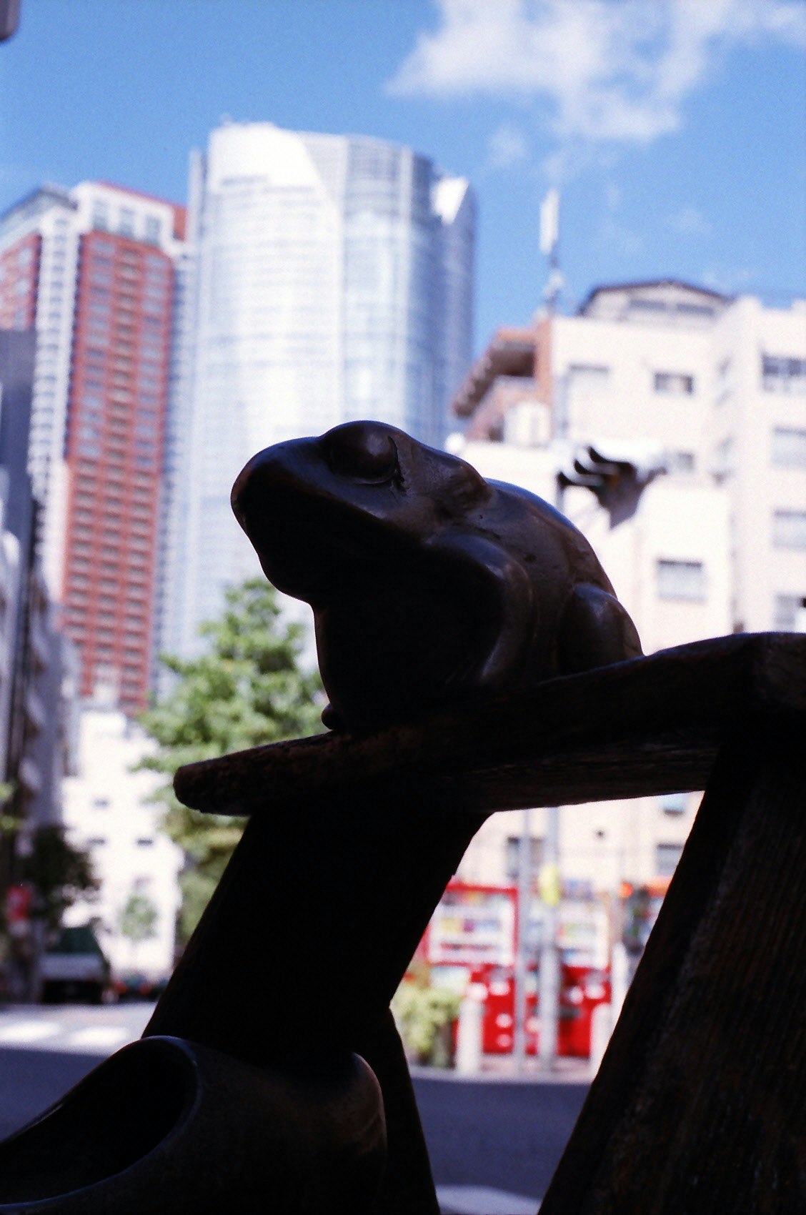 sculpture noire sur un piédestal avec des immeubles de grande hauteur en arrière-plan
