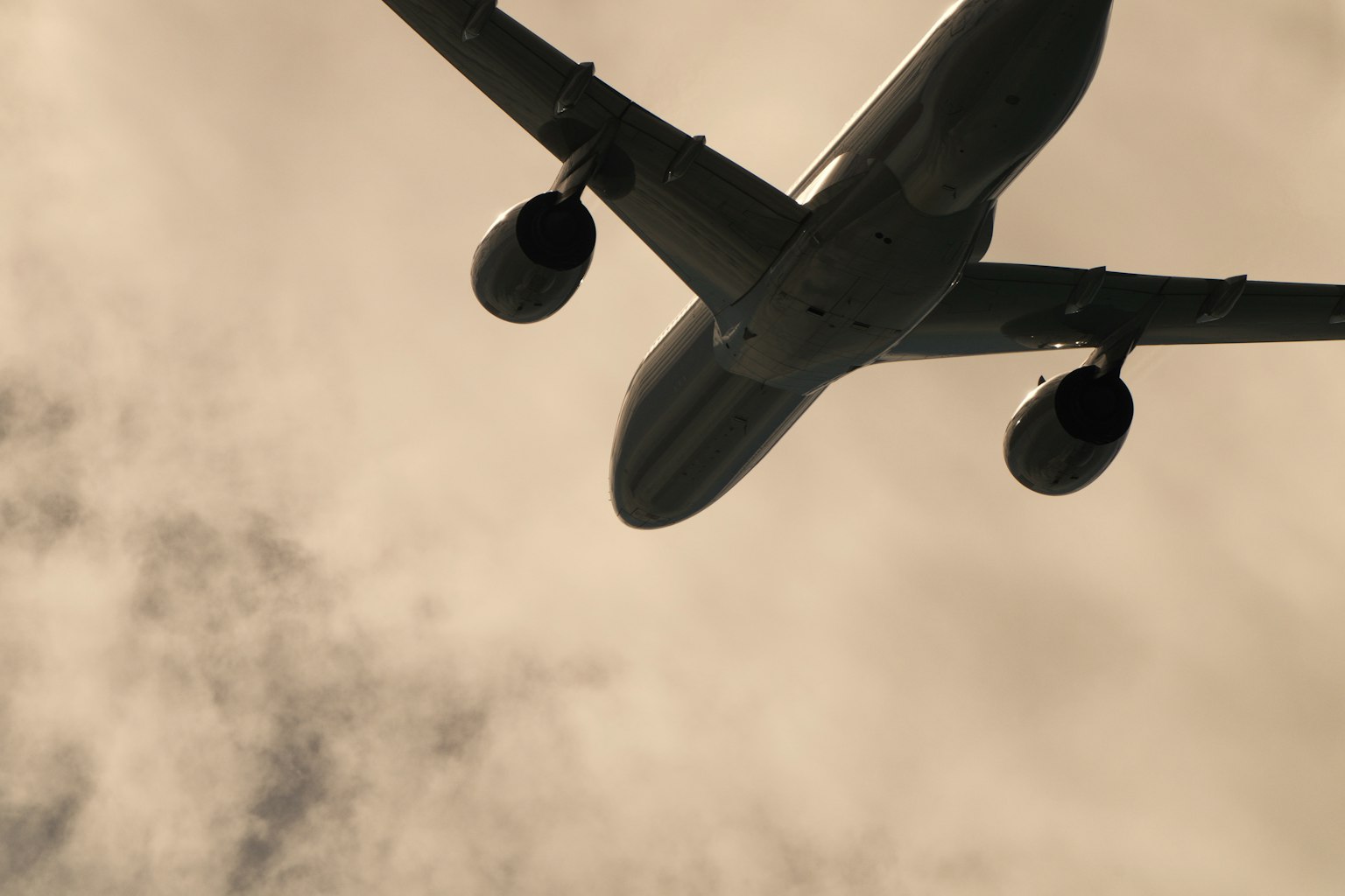 Unteransicht eines Flugzeugs, das über den Wolken fliegt