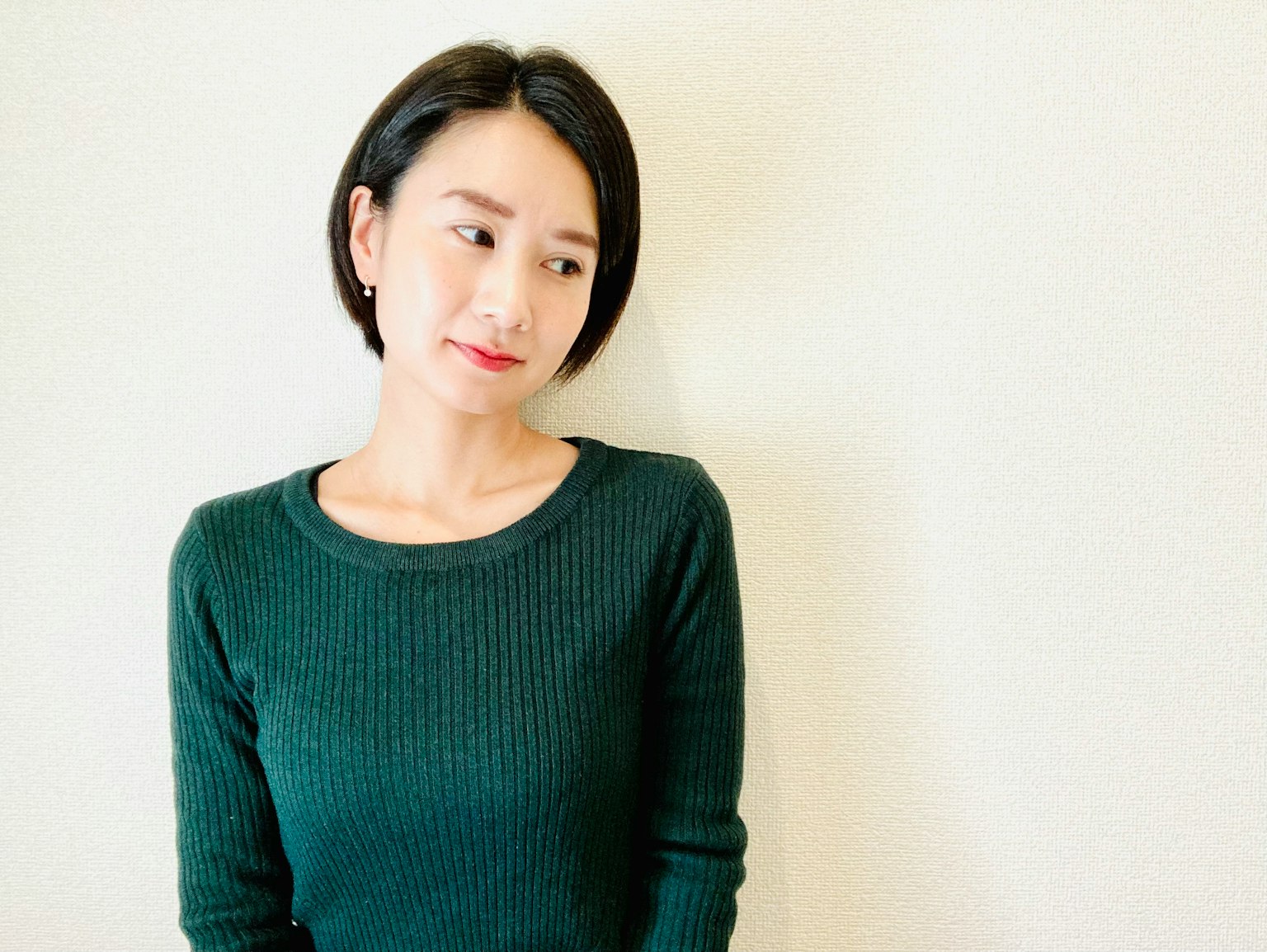 短发女性穿着绿色毛衣