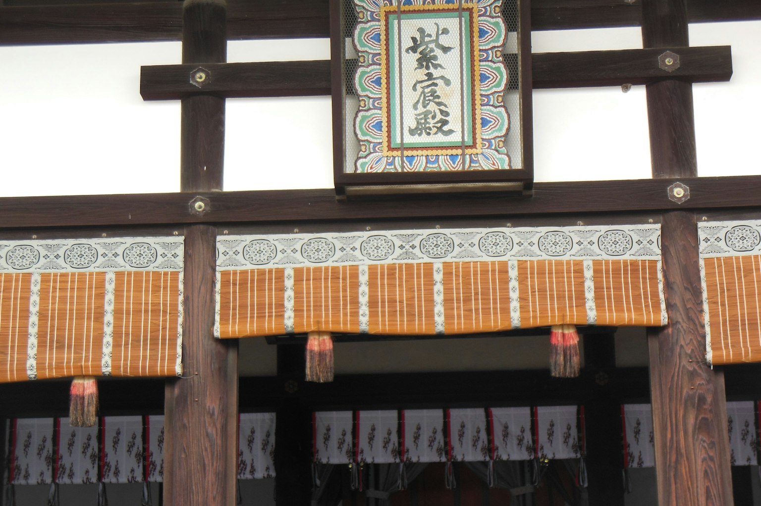 传统日本建筑入口，装饰性标志和竹帘