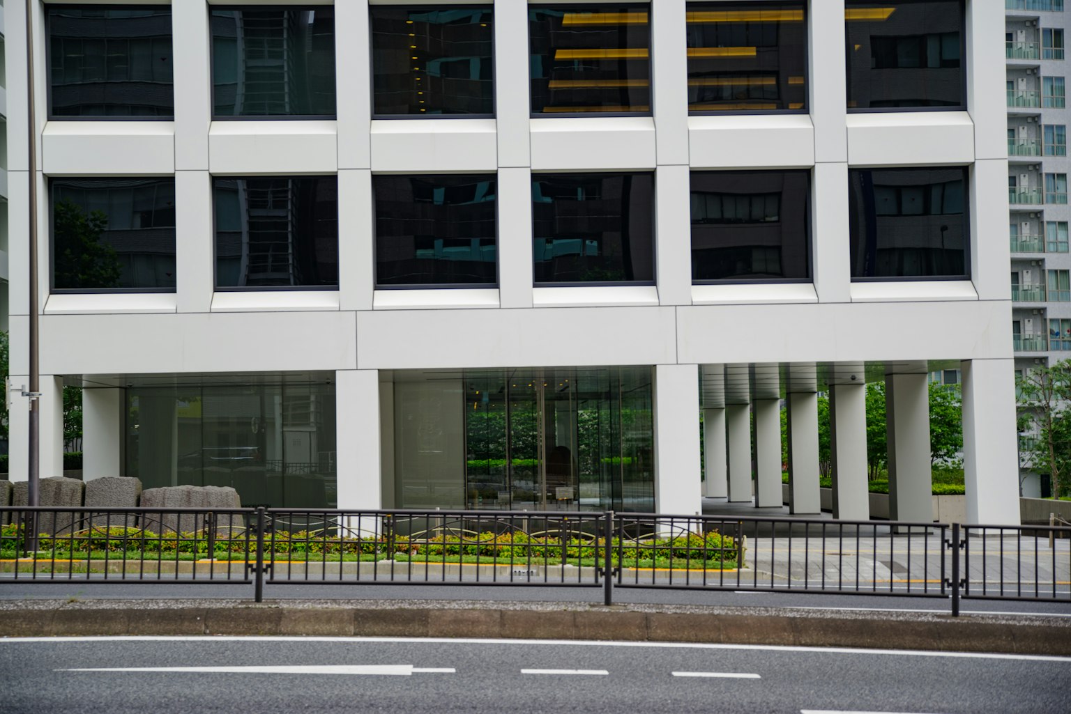 Sección de un edificio de oficinas moderno con fachada blanca y reflejos de vidrio